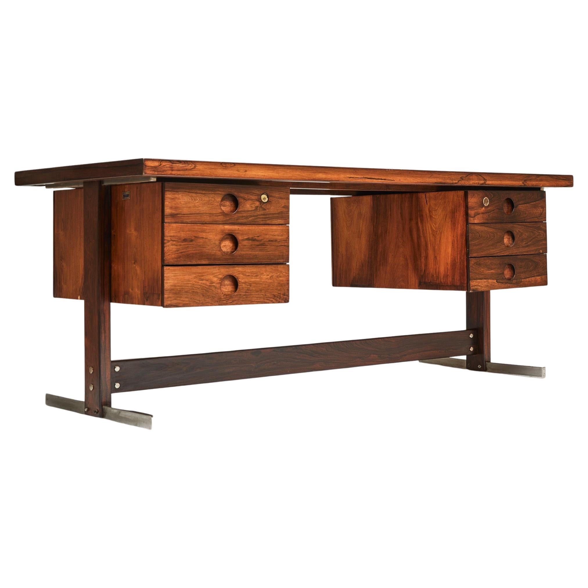 Available now, this Mid-Century Modern desk in Hardwood & Chrome by Sergio Rodrigues, is stunning!

This Brazilian Modern beauty is made of Brazilian rosewood, as known as Jacaranda and has six floating drawers and chrome-plated steel finishes.