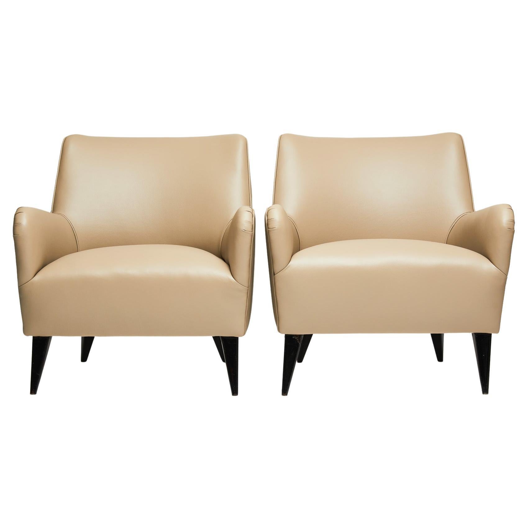 Available today, this Mid-Century Modern armchair set in beige leather & hardwood designed by Joaquim Tenreiro in 1955 is a showstopper. Full stop.

The stately pair consists of a hardwood structure with ebonized feet, spring seat and backrest in