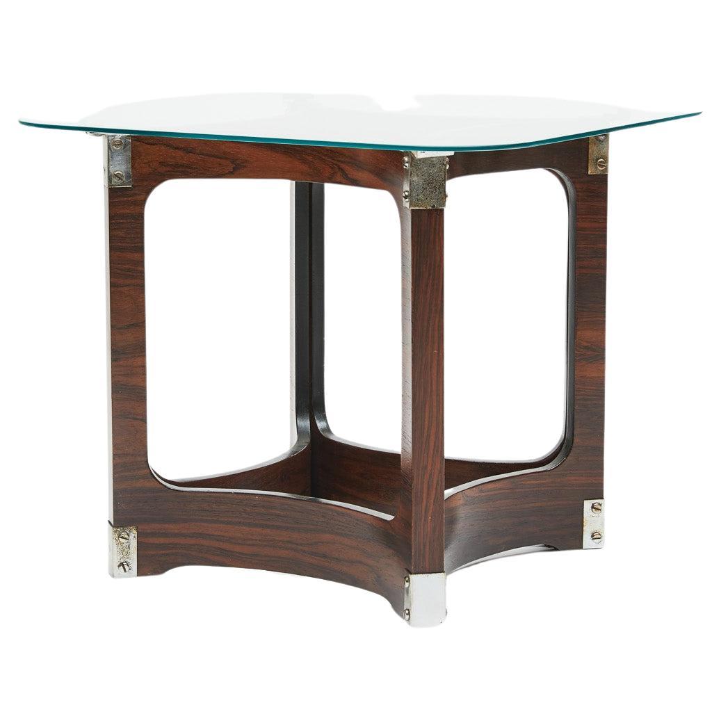 Disponible aujourd'hui, cette magnifique table d'appoint de Novo Rumo présente un design symétrique et est fabriquée en bois de rose brésilien courbé, connu sous le nom de Jacaranda, avec des finitions en métal chromé. Le dessus est en verre fumé,