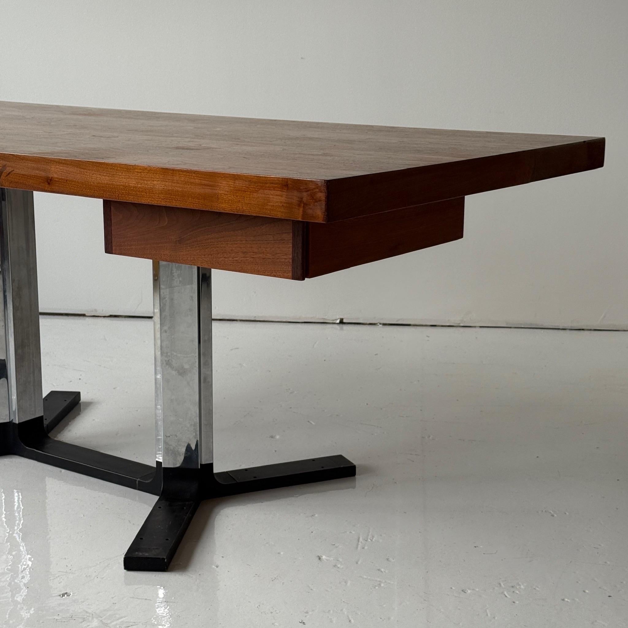c. 1960s. USA. Bureau de direction fait sur mesure, pouvant également servir de table à manger avec les tiroirs enlevés. Base chromée et plateau en noyer. 

