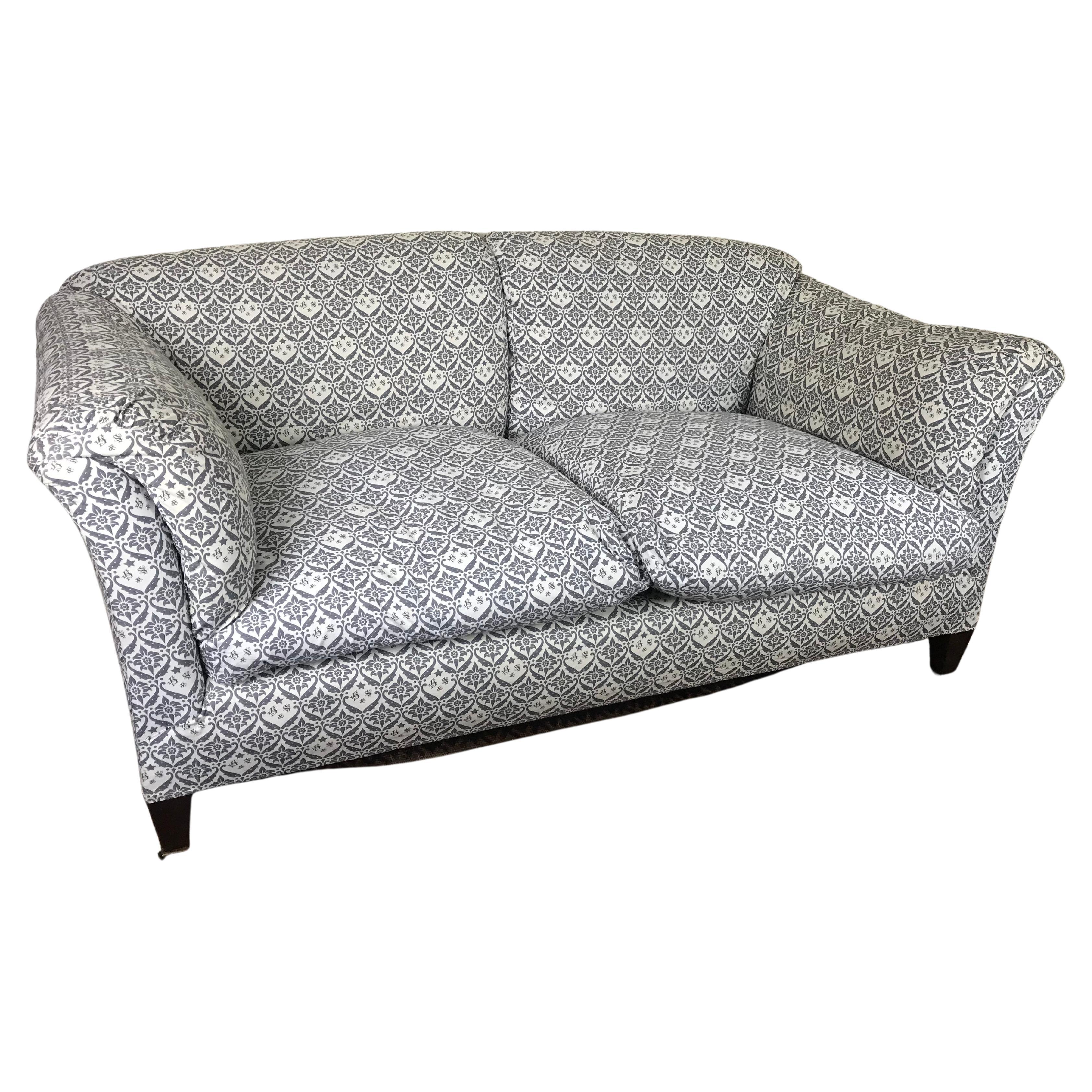 This elegant and extremely comfortable Howard and Sons Chaplain sofa has been re-upholstered to a very high standard in the original Howard and Sons monogrammed  ticking. There are two large feather and down filled removable cushions to the seat