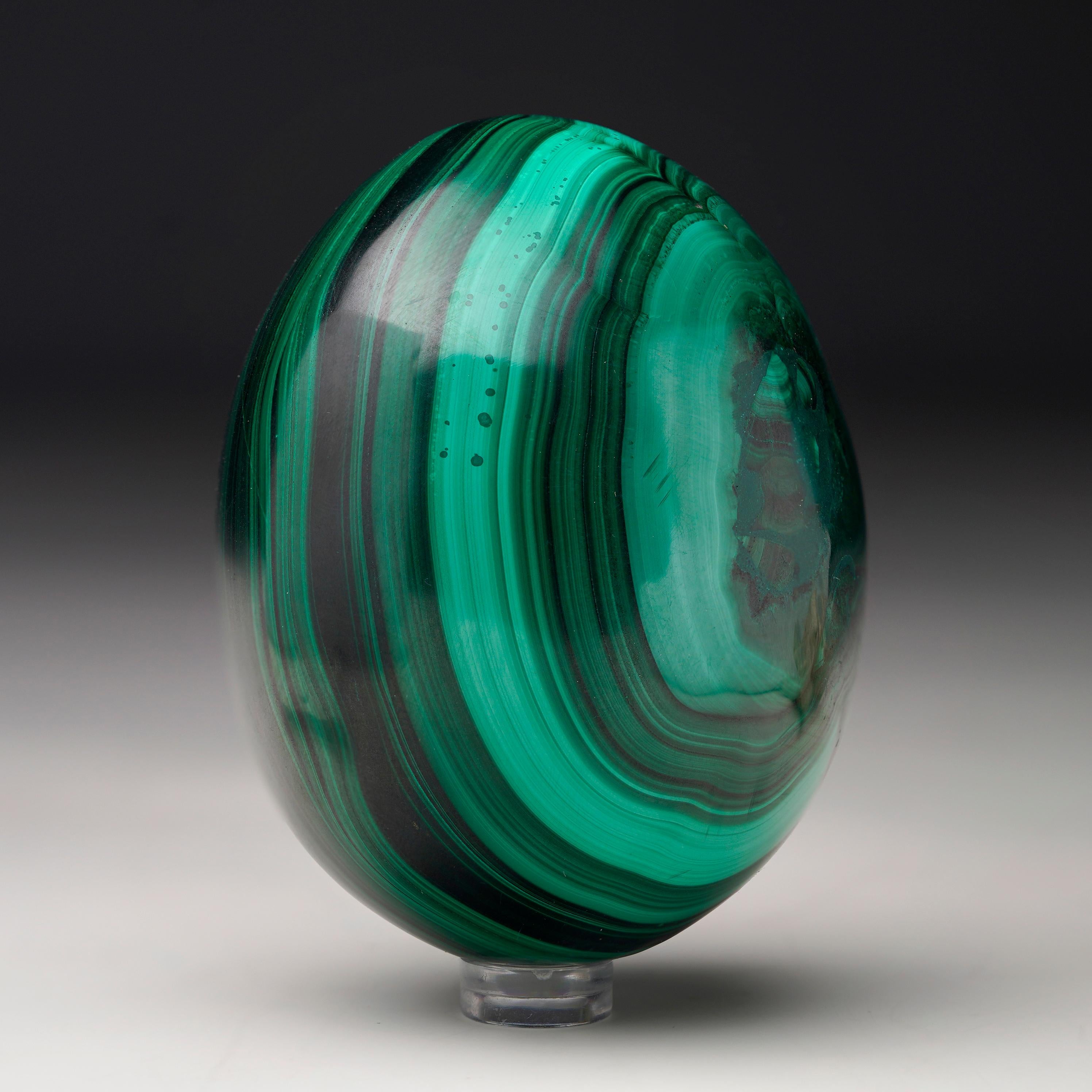 Crafted from solid, natural Malachite, this sizable hand-polished crystal egg is a work of art: foregrounding the stone’s signature swirling green banding, huge contrasting bullseyes, and rich, natural luster. A mesmerizing décor piece.

Malachite