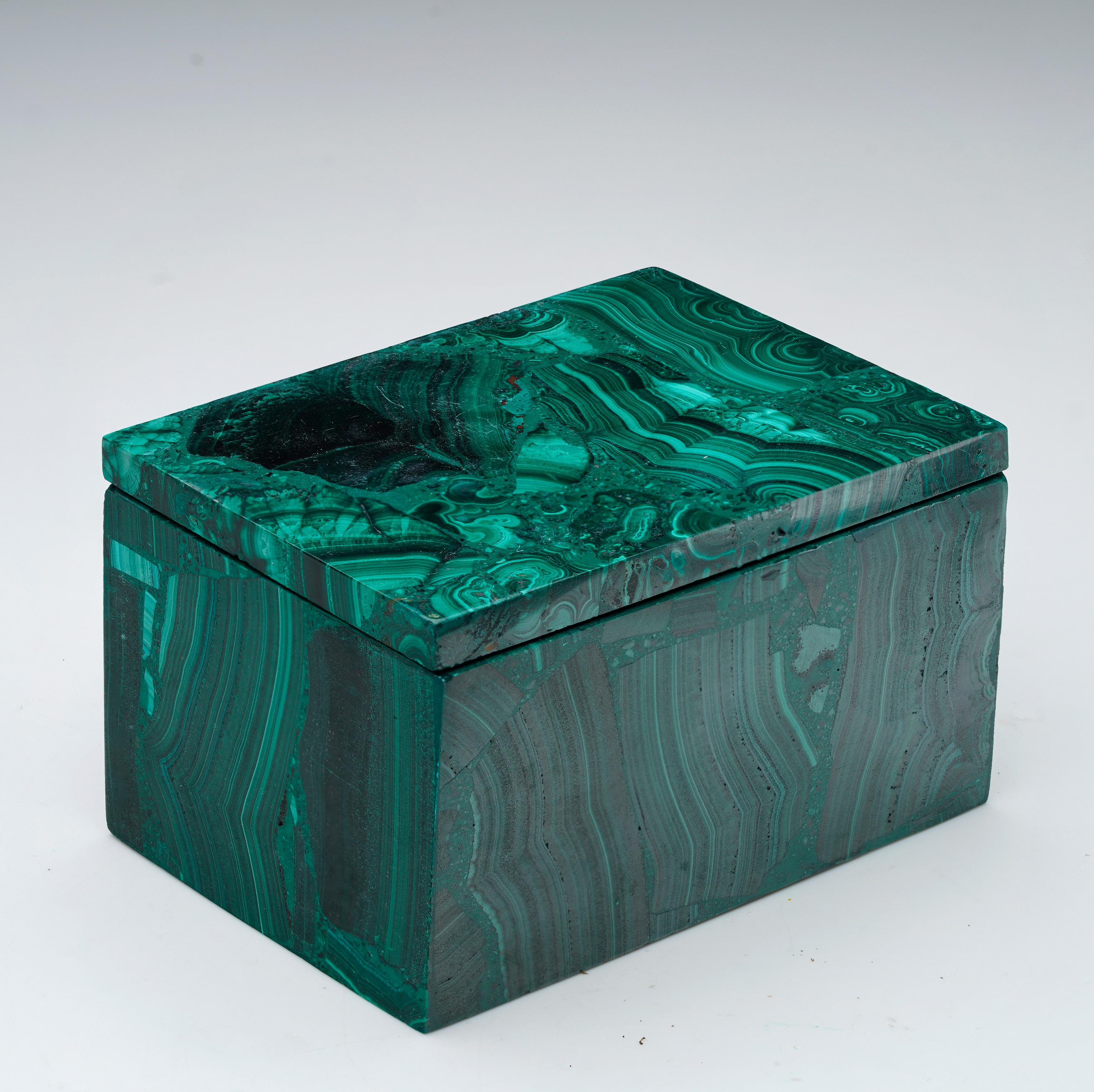 Fabriquée à partir de malachite naturelle, cette boîte décorative unique, sculptée à la main, est une œuvre d'art singulière qui présente les bandes vertes tourbillonnantes caractéristiques de la pierre, des taches contrastées et un lustre riche et