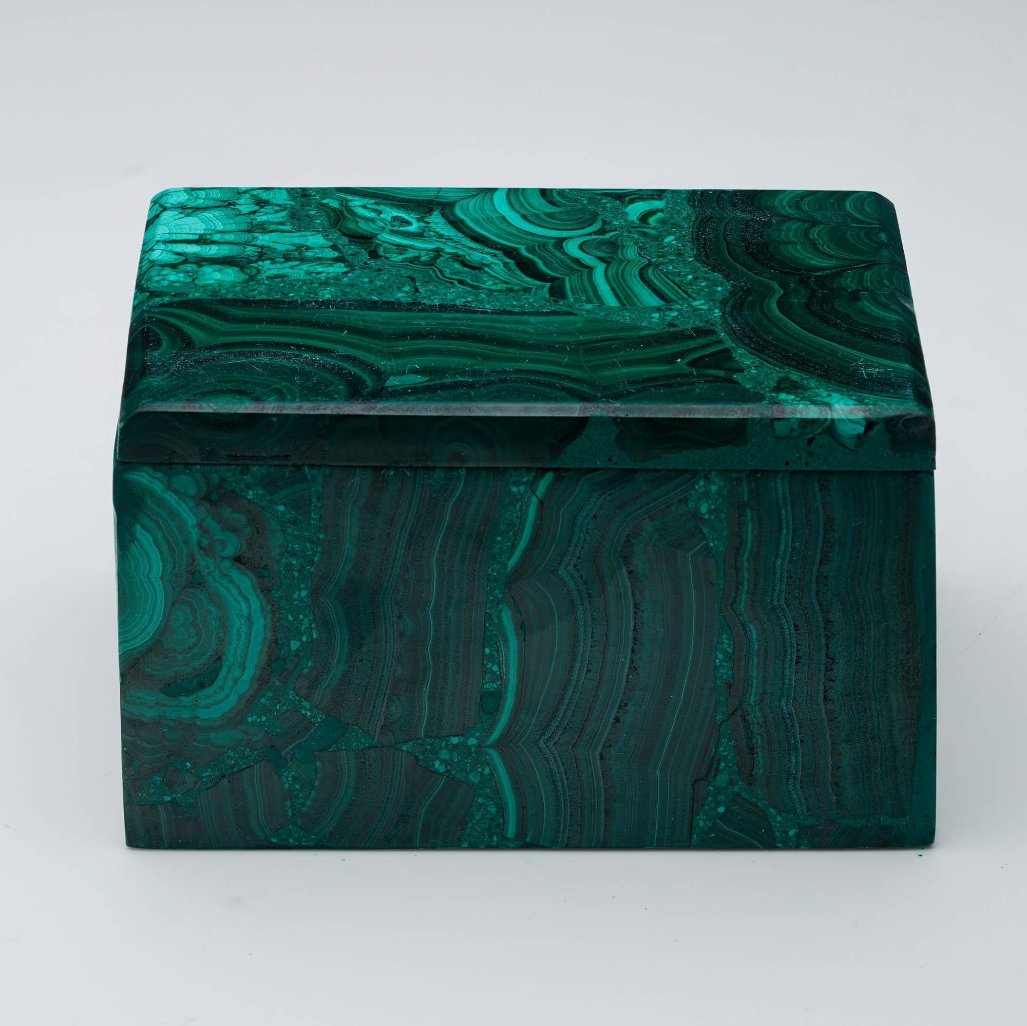 Fabriquée à partir de malachite naturelle, cette boîte décorative unique, sculptée à la main, est une œuvre d'art singulière qui présente les bandes vertes tourbillonnantes caractéristiques de la pierre, des taches contrastées et un lustre riche et