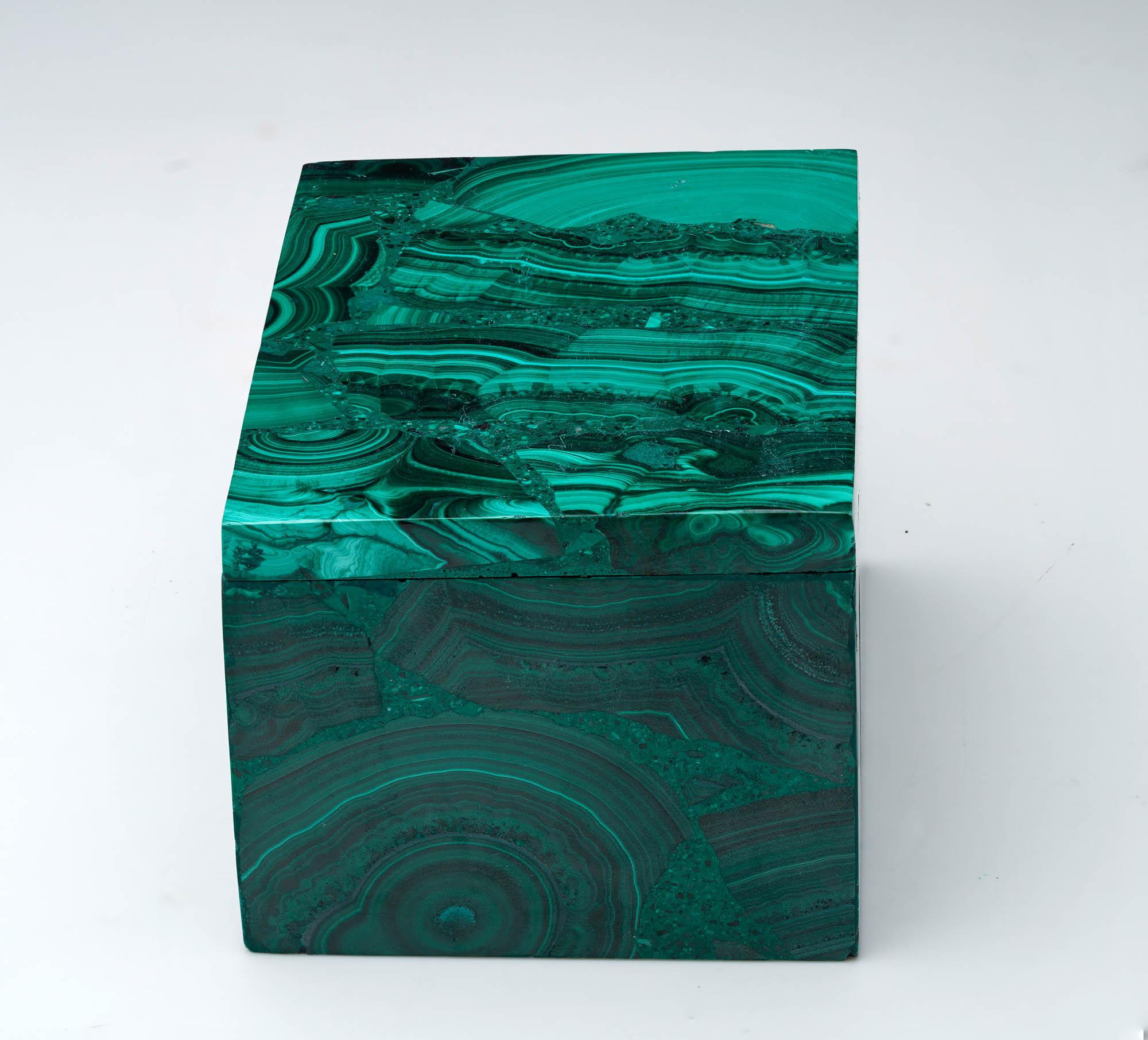 Fabriquée à partir de malachite naturelle, cette boîte décorative unique, sculptée à la main, est une œuvre d'art singulière qui présente les bandes vertes tourbillonnantes caractéristiques de la pierre, des taches contrastées et un lustre riche et