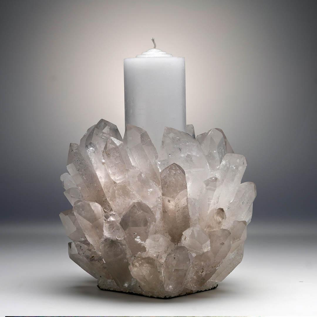 Verleihen Sie Ihrem Raum Eleganz und leuchtende Energie mit diesem handgefertigten Quarz-Punkt-Kerzenhalter, der eine auffällige Ansammlung echter Quarzkristalle um einen festen Glaseinsatz herum aufweist. Dieses einzigartige Stück, das für eine