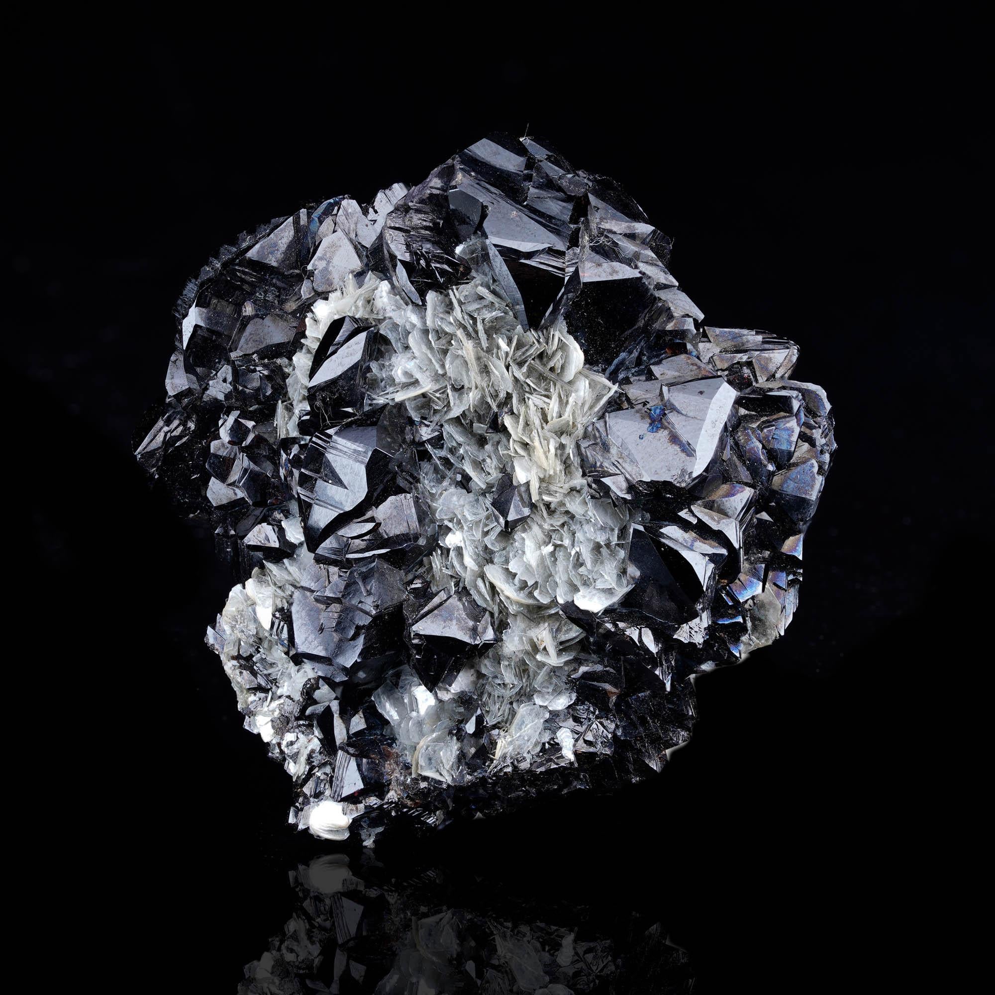 Este excepcional espécimen de la renombrada mina Pingwu, en la provincia china de Sichuan, presenta una espectacular combinación de cristales de casiterita de color negro azabache con lustre brillante y terminaciones afiladas, bellamente