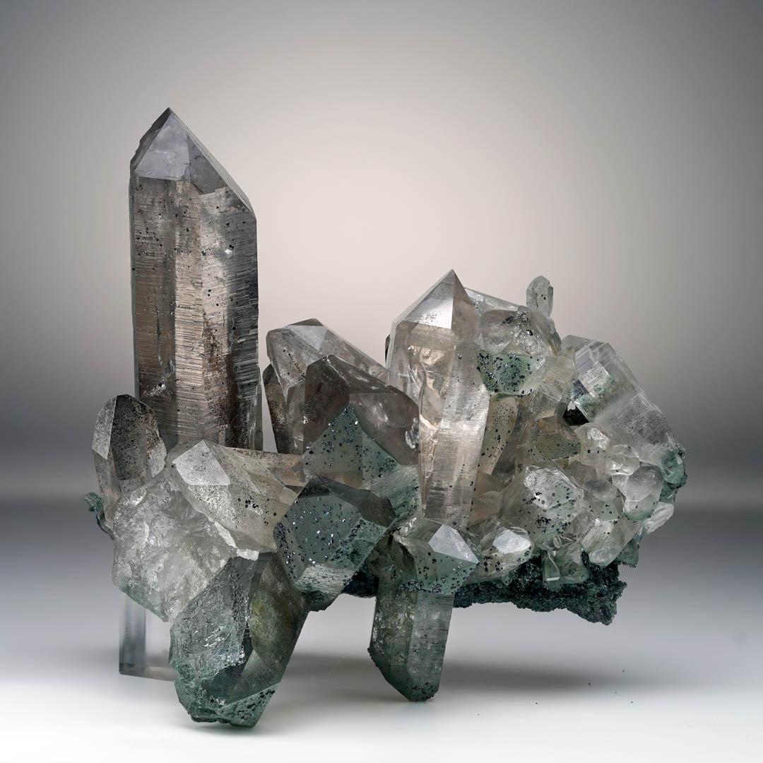 The highest quality from the heights of the Himalayas, this truly unique and display-worthy Chloride Quartz cluster features a plethora of perfect natural terminations that achieve water-clear translucency juxtaposed with the sparkling, earthy green