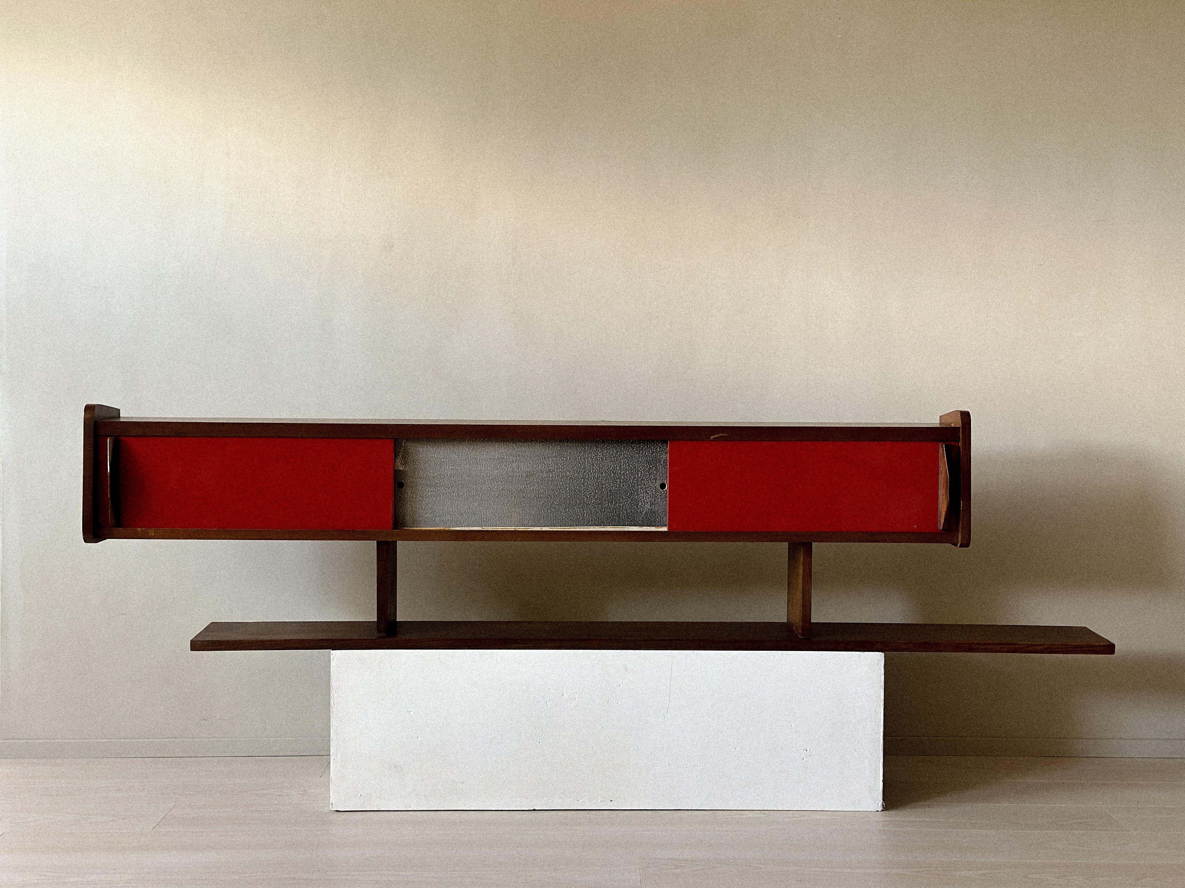 Mid-Century Modern Shelf with Sliding Doors, in the Style of Charlotte Perriand, France, c. 1950s

Wall-mounted shelf with sliding doors and open compartments. Clean lines and functional design. Wear consistent with age and use. Marks, scratches. 