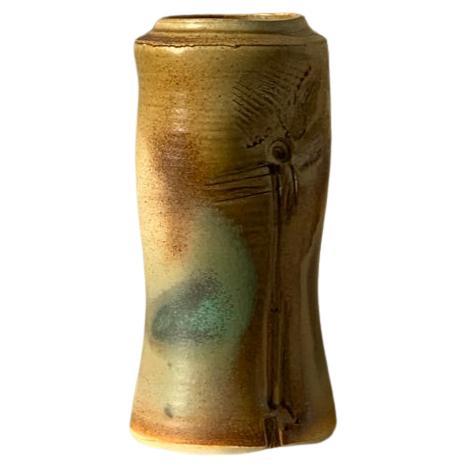 A multi-color ceramic pottery vase with carved design. 