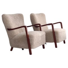 Pair of 1930s danish lounge chairs in stained beech, reupholstered in shearling