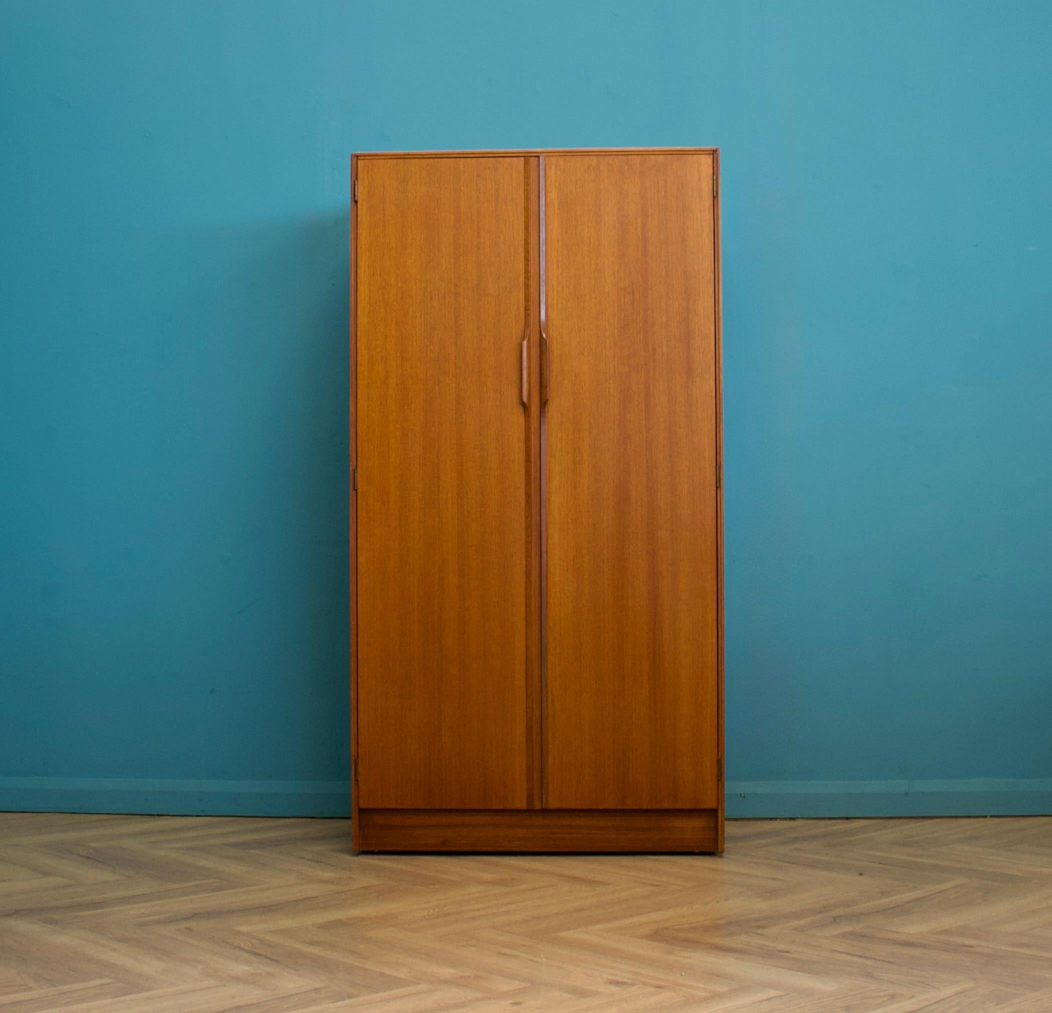 A freestanding double door teak wardrobe from Austinsuite
Made during the 1960s

Fitted out with a clothes rail, shelves and drawers
The style of this wardrobe is quite minimalist - with it's clean lines

This wardrobe will flat pack

The matching