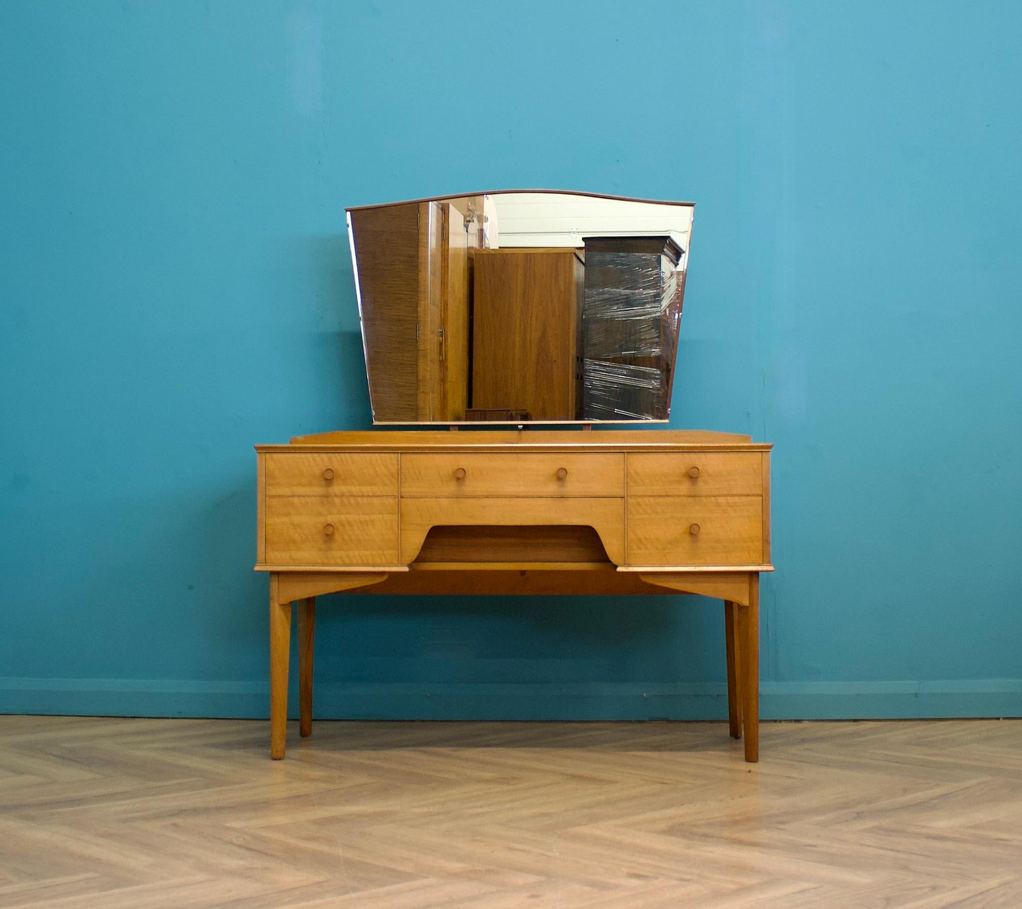 A mid-century walnut dressing table from Alfred Cox, circa 1950s.


The dressing table includes six drawers and a fixed mirror


Height to the top of the mirror is 138 cm 
