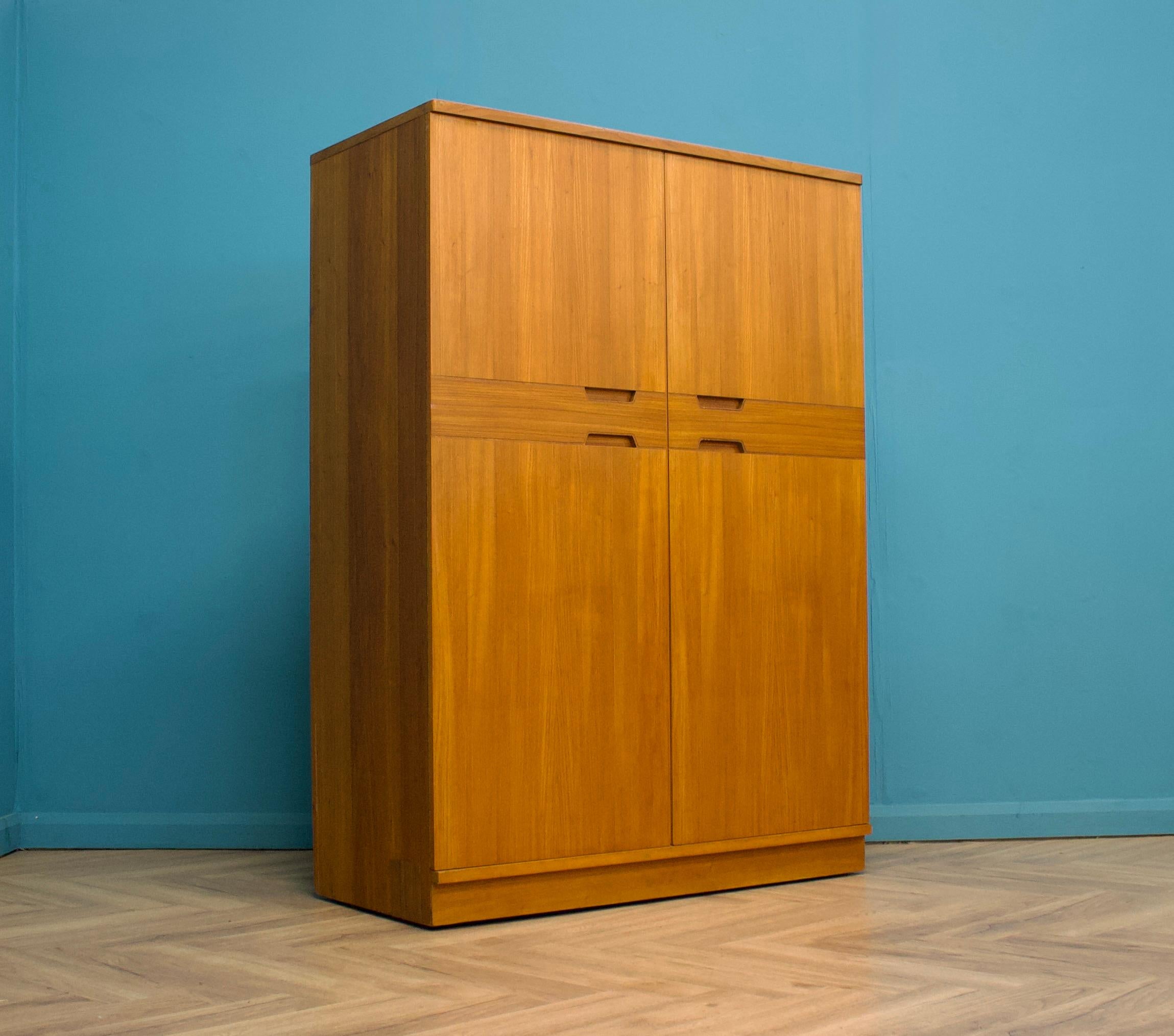 Un armadio freestanding a due ante in teak di Uniflex, progettato da Gunther Hoffstead.
Realizzato negli anni '60

Dotata di un'asta appendiabiti per tutta la larghezza, due ripiani e due cassetti
Lo stile di questo guardaroba è piuttosto