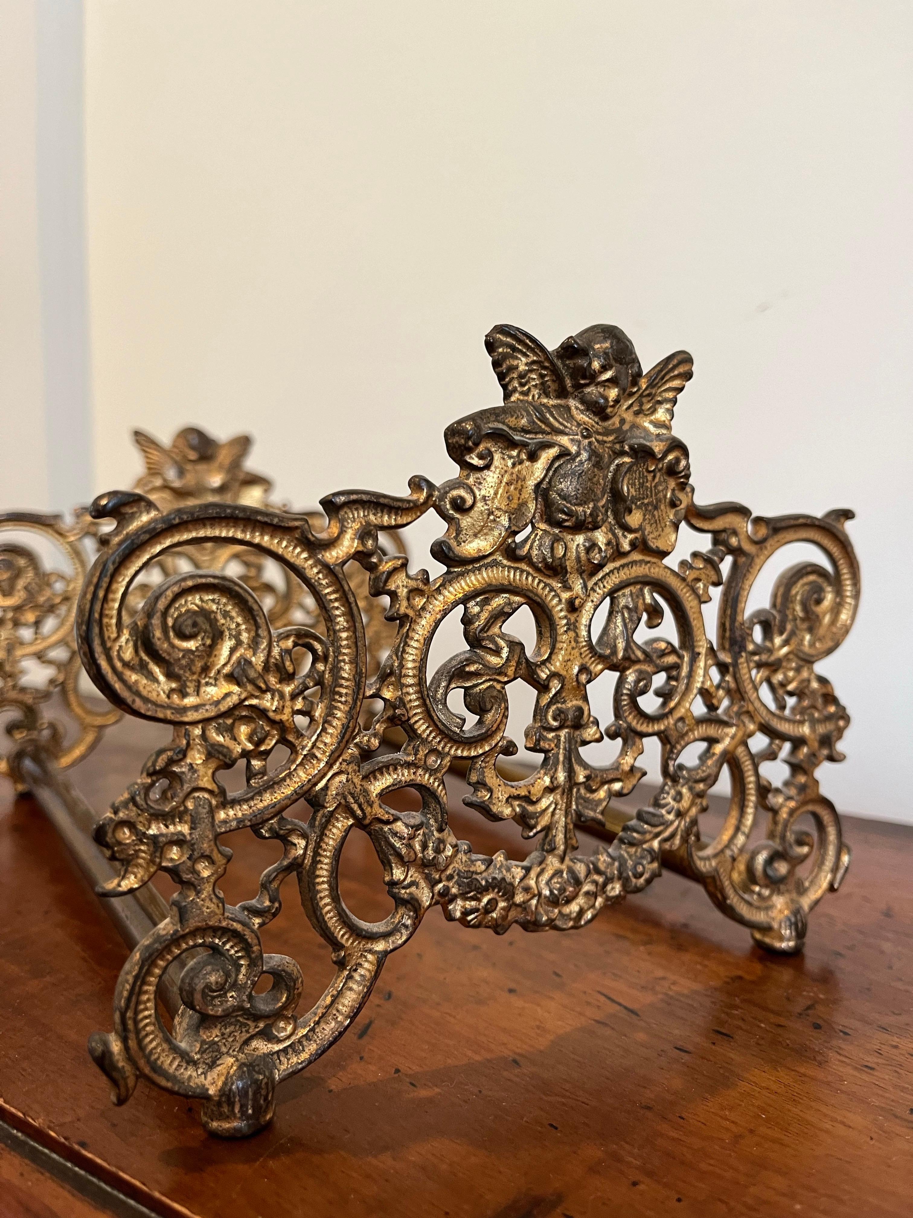Antique adjustable book slide with detailed filagree and cherub detail. Extending to 15