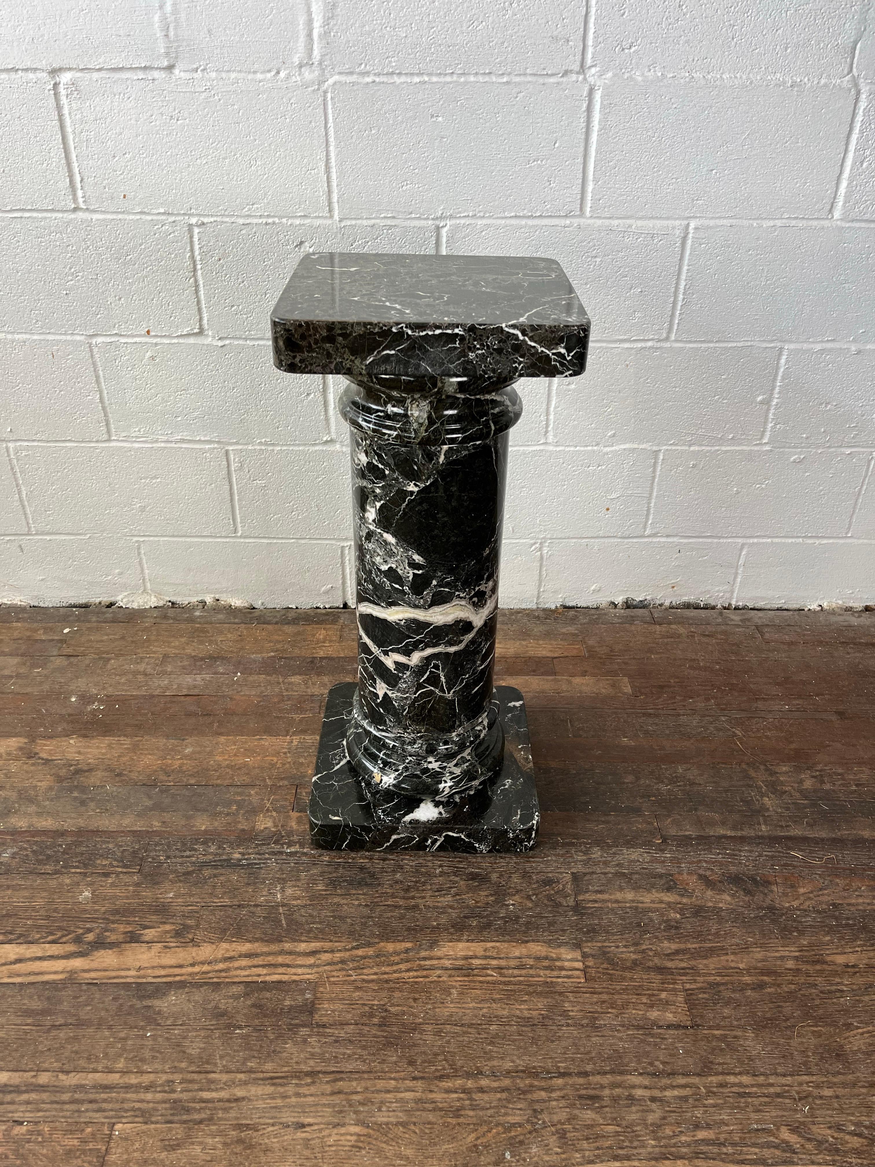 Beautiful neoclassical marble pedestal column, late 20th century. Probably hailing from Italy, this handsome column is of the deepest licorice black featuring stunning intricate veining in tones of cream and truffle. Column dismantles into five