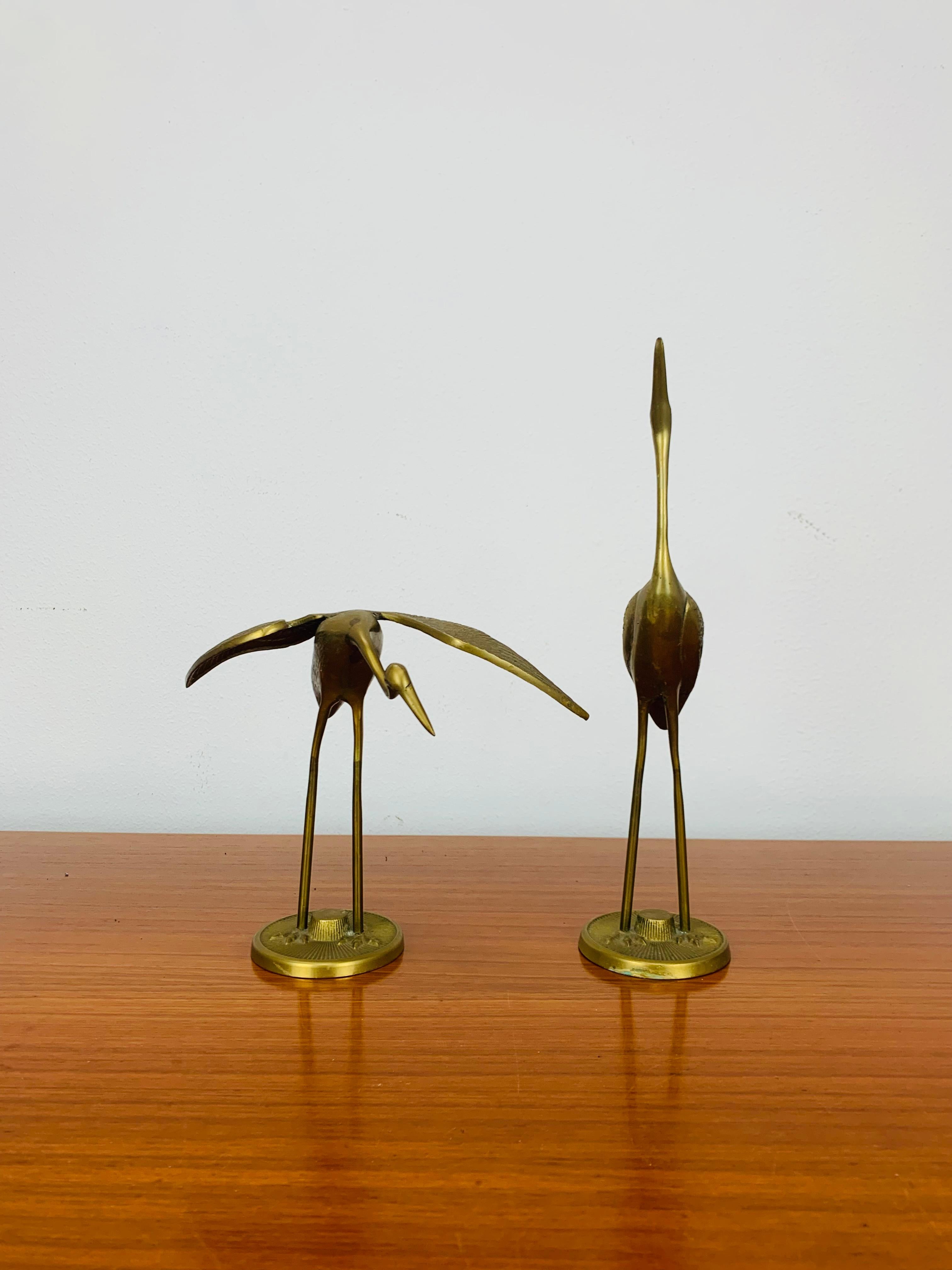 Coppia di aironi o gru in ottone, degli anni '70. 
Misure: altezza 17 cm e 30,5 cm / larghezza 9 cm e 21,5 cm / diametro base 8 cm. 