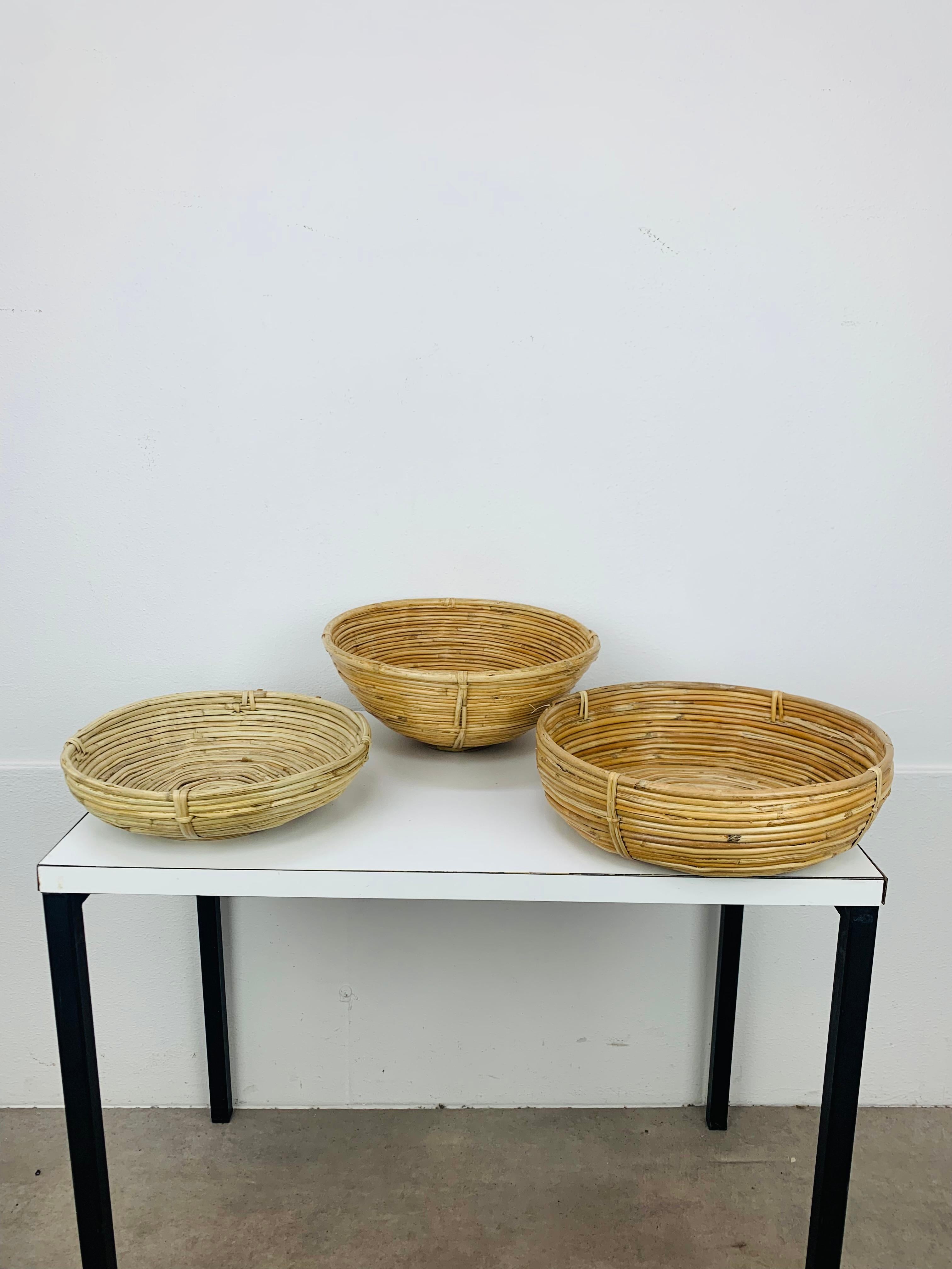 Set di tre cesti in rattan italiani nello stile di Gabriella Crespi, intorno agli anni '60. Buone condizioni,  pezzi d'arredo organici molto belli.

Misure: altezza 6/8/11,5 cm, diametro 23,5/27/26 cm.
