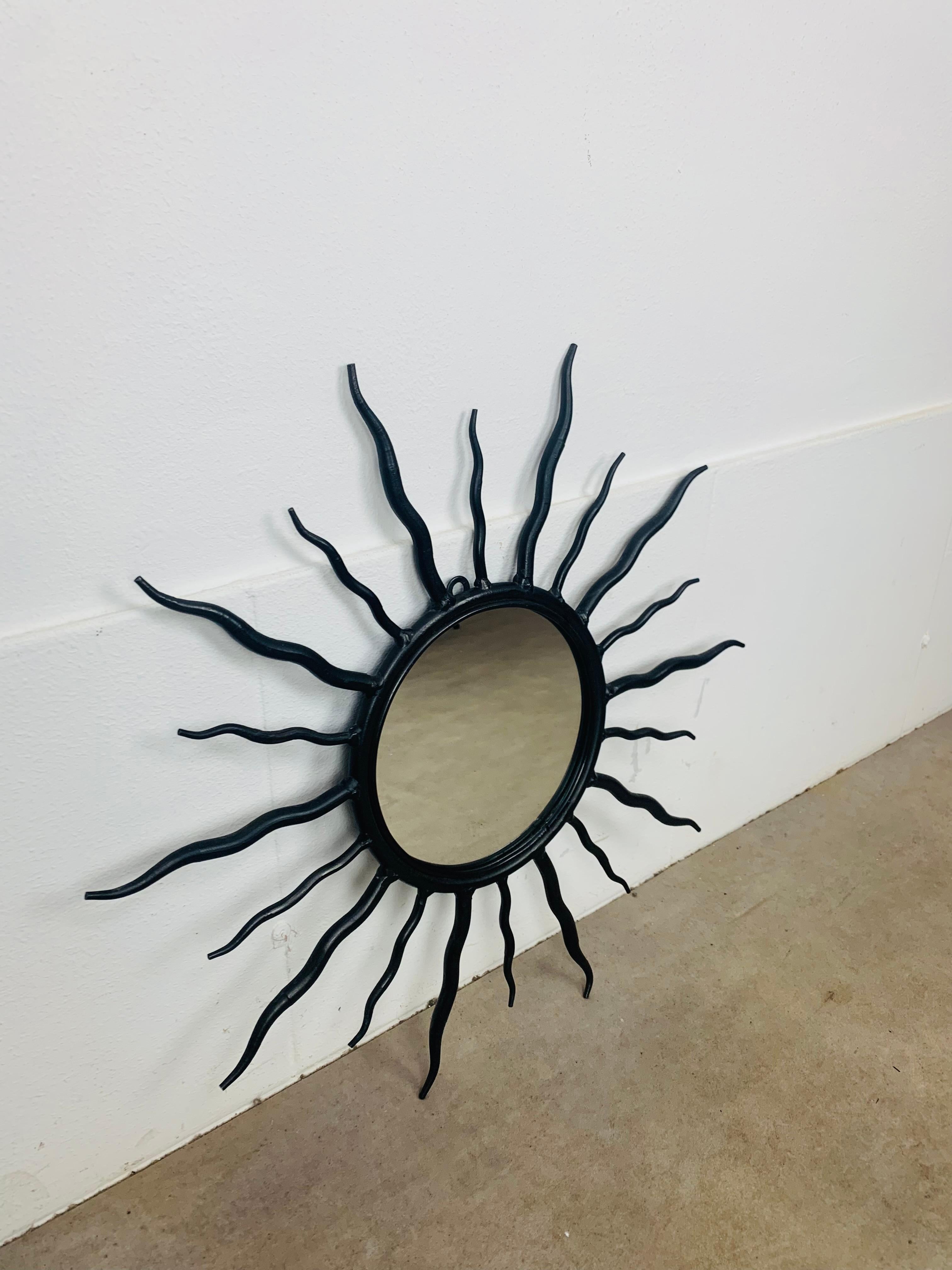 Miroir ensoleillé réalisé en fer forgé dans les années 1970. Diamètre 57 cm, diamètre du verre 19,5 cm. 