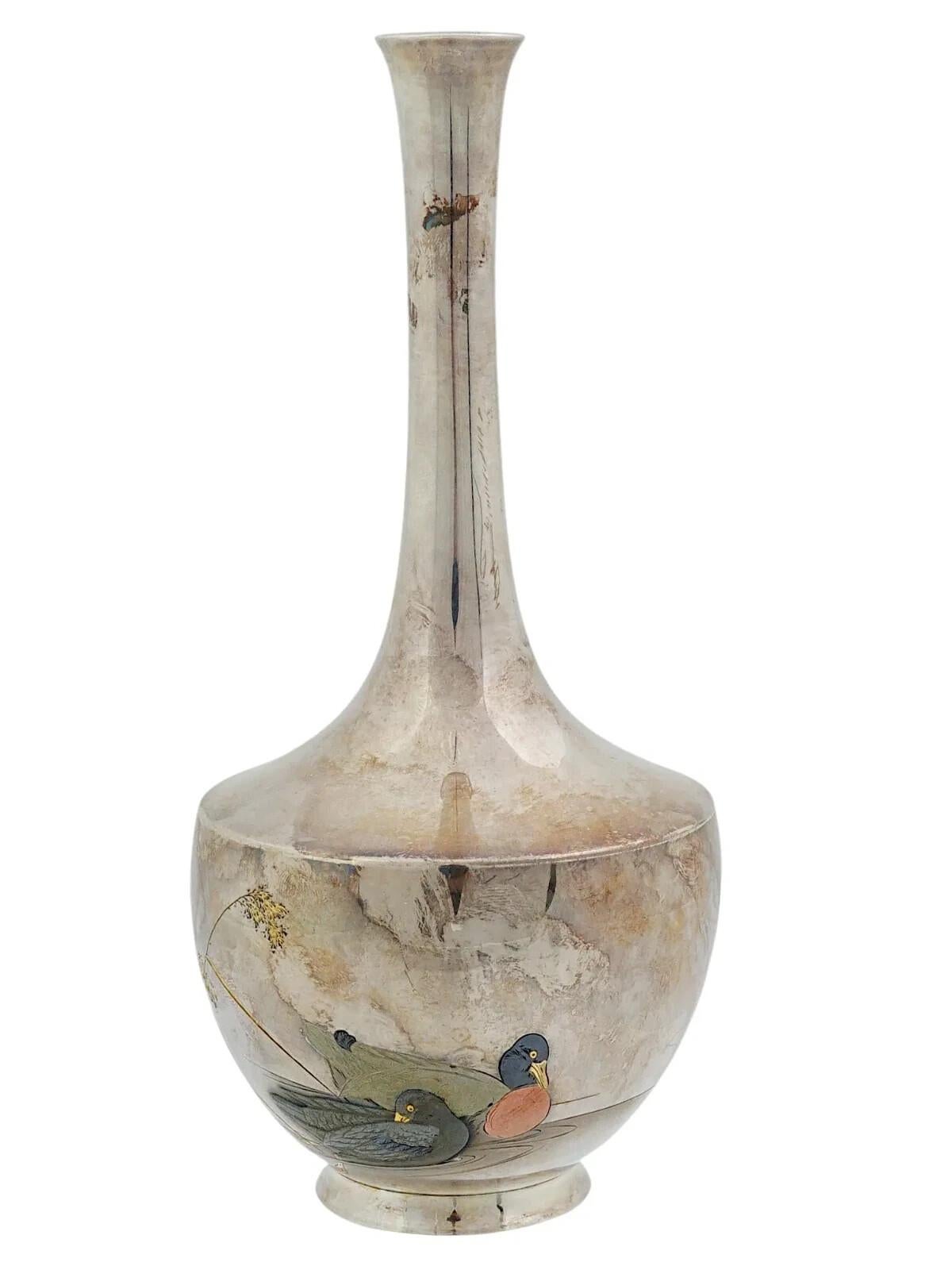 Un vase en métal fin de l'époque de l'empereur Meiji, de 1868 à 1912. Cet élégant vase japonais en argent et Shakudo à décor multi-métallique représente deux canards nageant parmi des roseaux. Avec les marques de la période Meiji pour Jungin, en