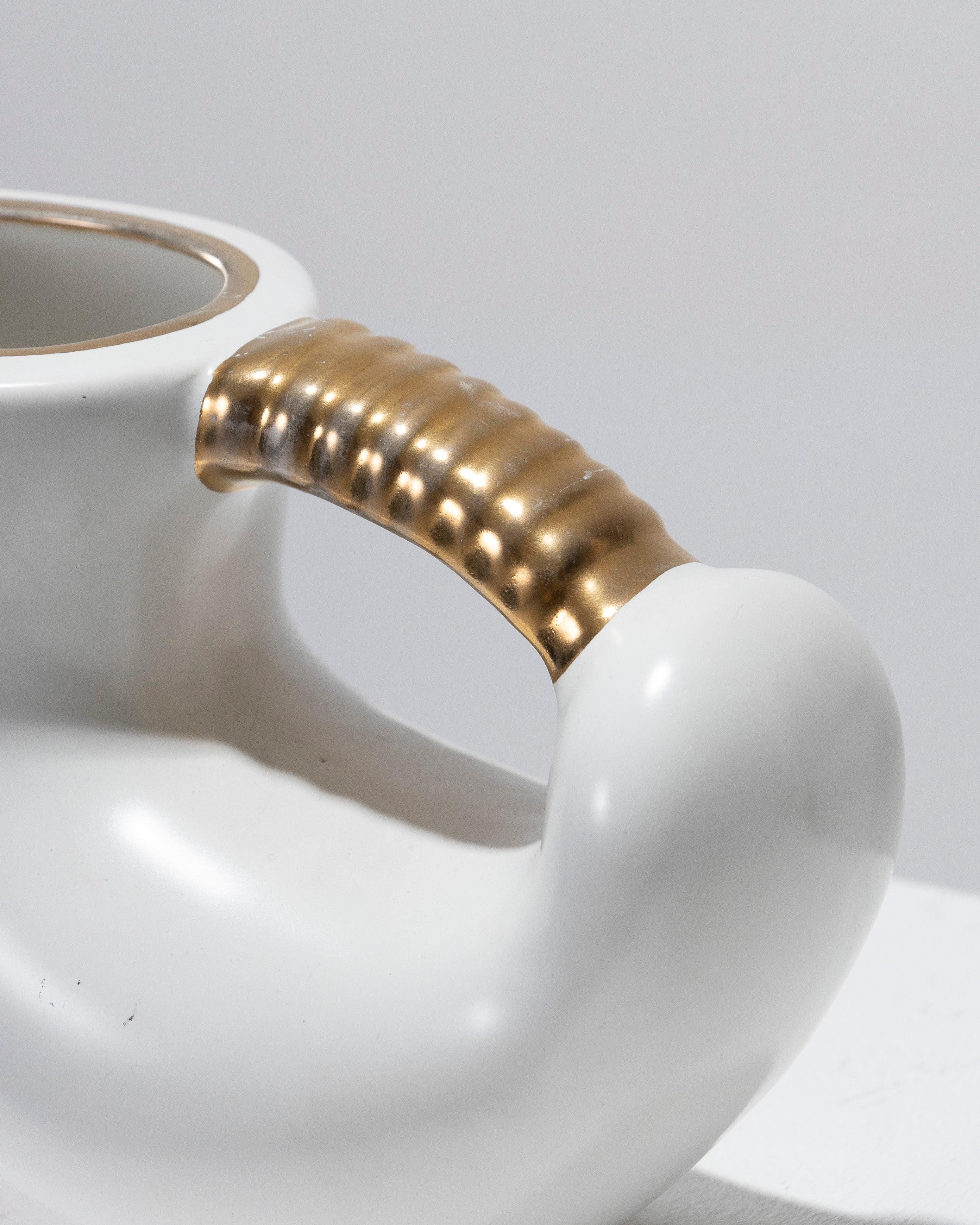 Delightful pitcher with a rounded body and a pointed spout, made in France in the 1950s. Finished with a white glaze, accented by gold lines, and a handle adorned with raised gold detailing. In excellent condition.
DV2046