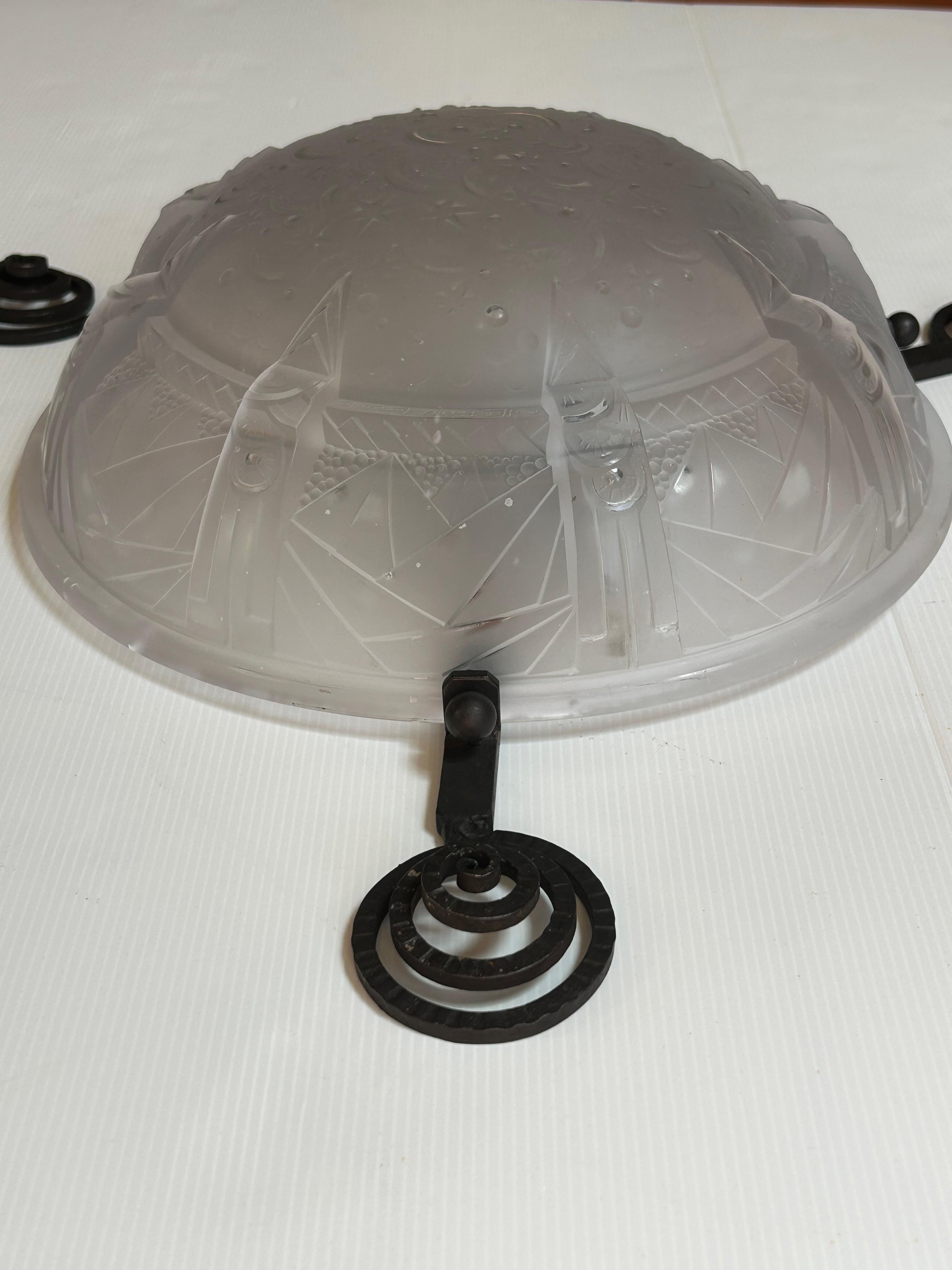 Art Deco ceiling light circa 1930.
Wrought iron frame with 3 lights. E14 socket, electrified, ready to use.
Molded glass bowl signed Muller Frères.
In very good condition.

Total height: 13 cm
Diameter of bowl: 35 cm
Total diameter: 60 cm
Weight: 5