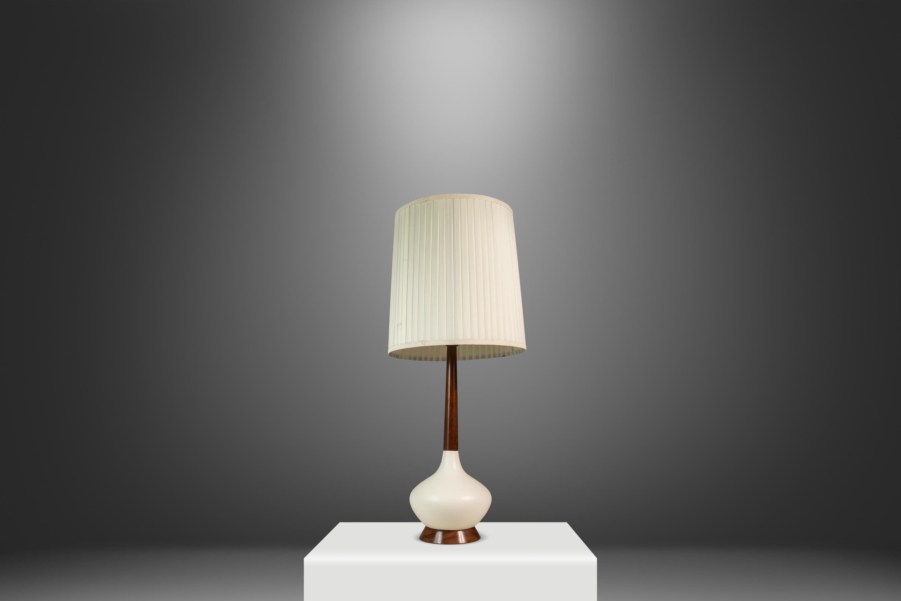 Cette lampe de table captivante de style moderne du milieu du siècle, fabriquée aux États-Unis dans les années 1960, présente une forme allongée en goutte d'eau qui respire l'élégance organique. La base de la lampe est fabriquée à partir d'un riche