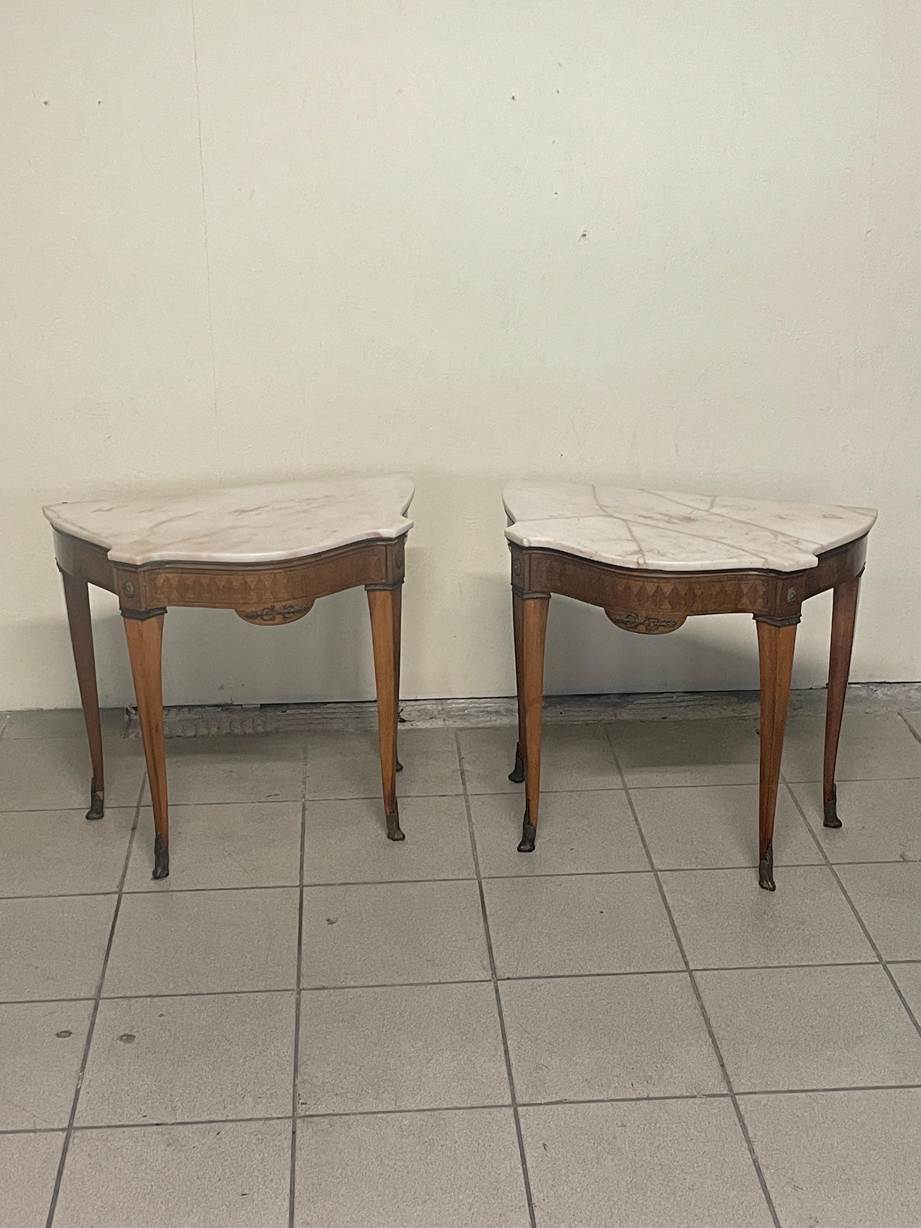 Coppia di comodini anni '40-'50 nello stile di Paolo Buffa.

Struttura in legno di mogano così come la lastronatura oltre a legni pregiati.

Cassettina a scomparsa sotto il piano di marmo.
Particolari in Ottone 
I piani sono entrambi in marmo bianco
