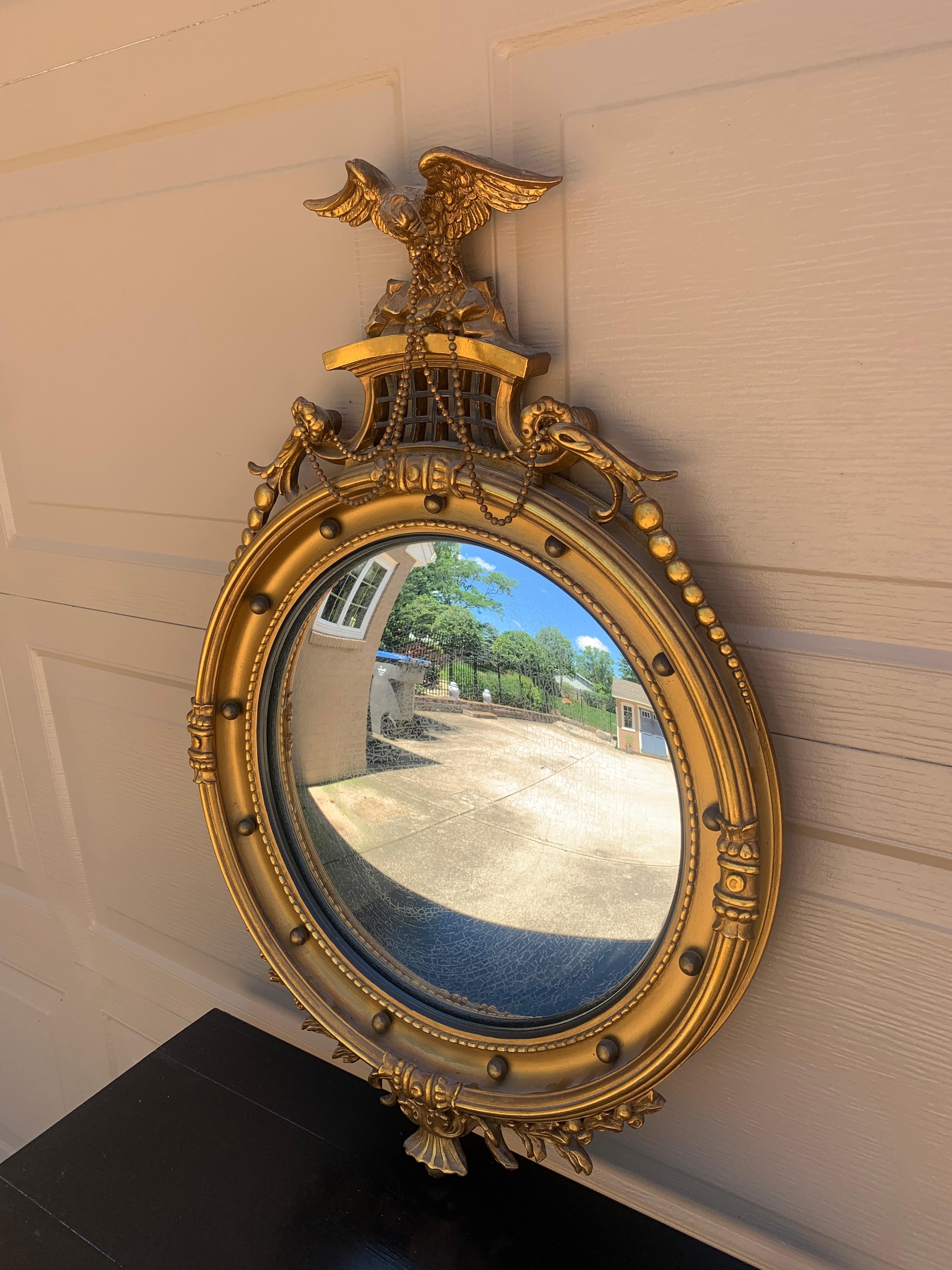 A gorgeous Federal or Regency style convex bullseye wall mirror featuring a carved eagle with open wings and 13 small spheres representing the original 13 colonies around the inside perimeter.

USA, Mid-20th Century

Gilt composition frame, with