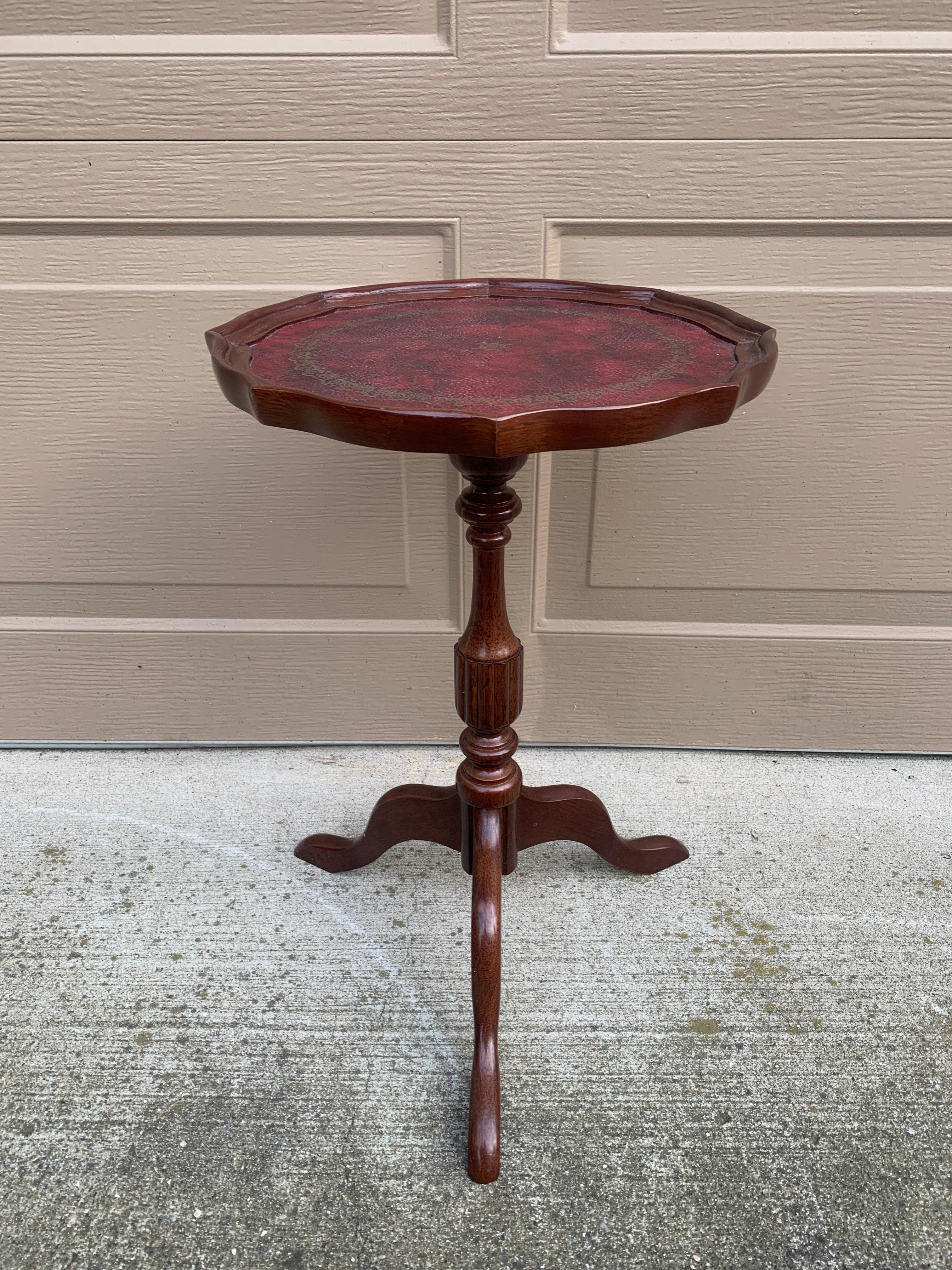 A gorgeous Georgian style round scalloped edge side table or drinks table

USA, Circa 1980s

Carved mahogany, with embossed red leather top

Measures: 13.25