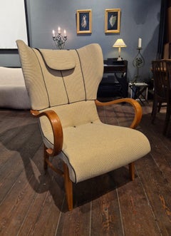 Sillón sueco moderno con respaldos laterales, retapizado con detalles de piel, década de 1940.