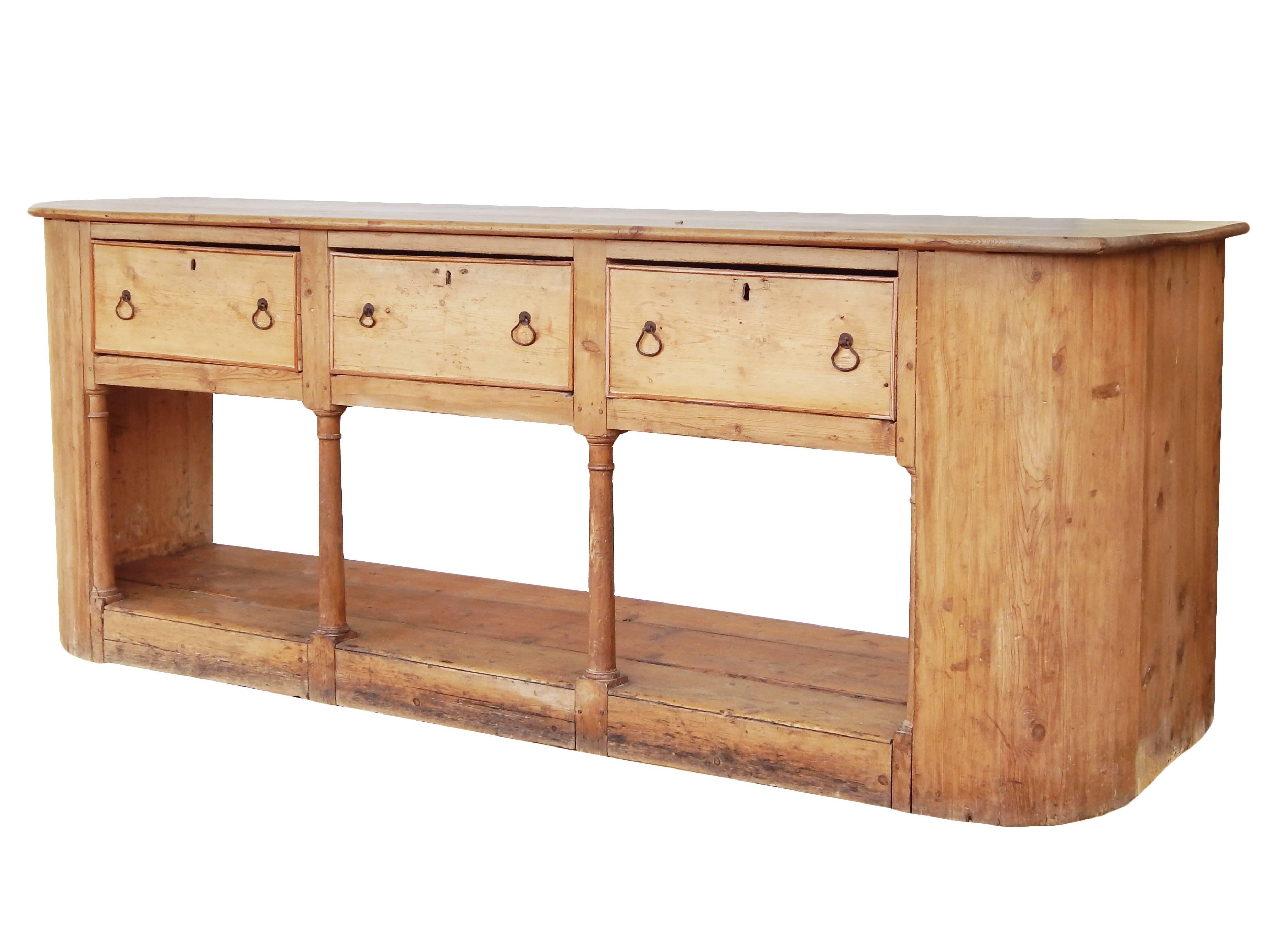 Exceptional English pine sideboard with curved end panels and carved columns. A back board can be made if the open back is not appropriate for the setting.