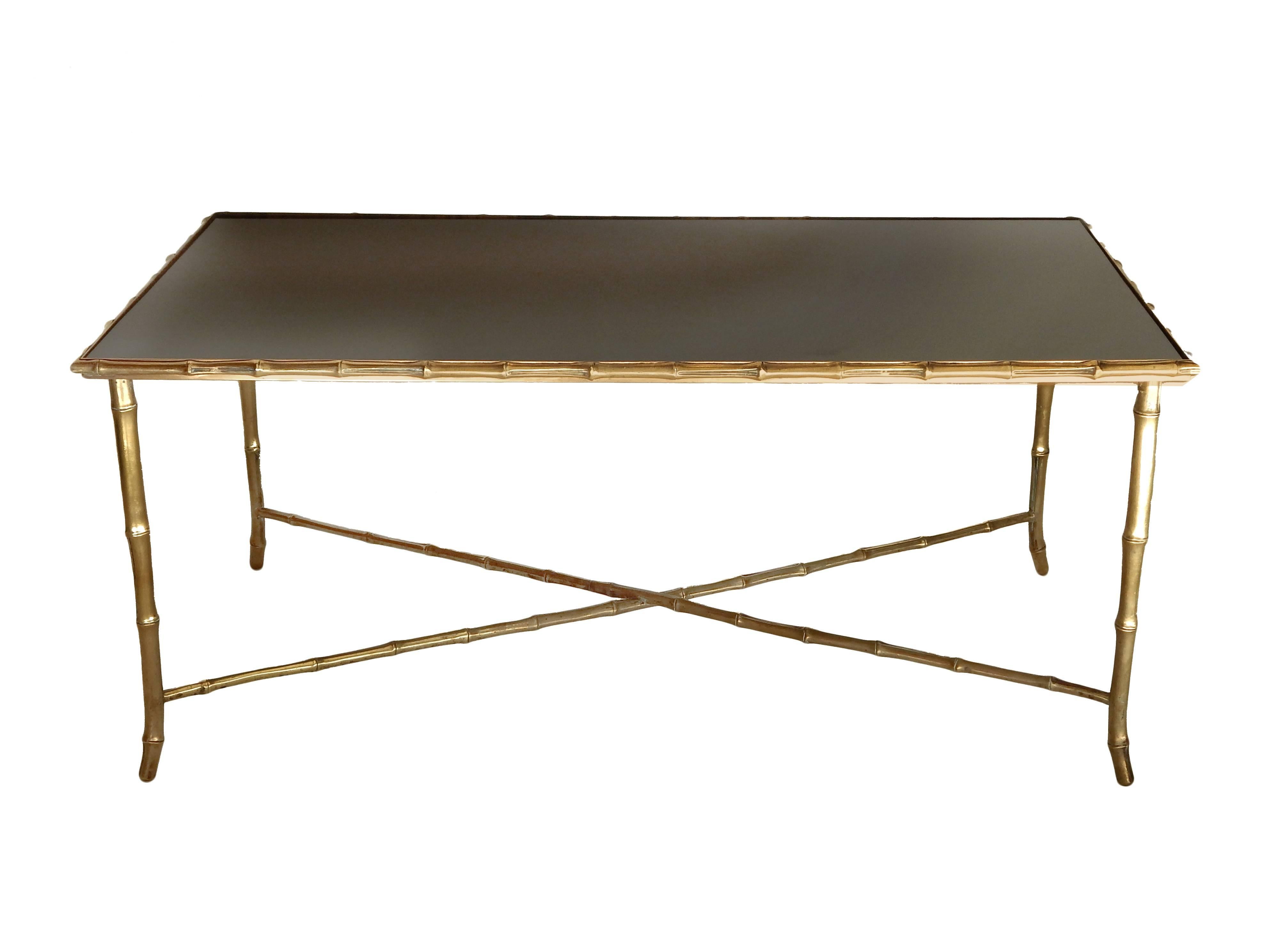 Heavy brass faux bamboo coffee table with black glass top, in the style of Bagues.