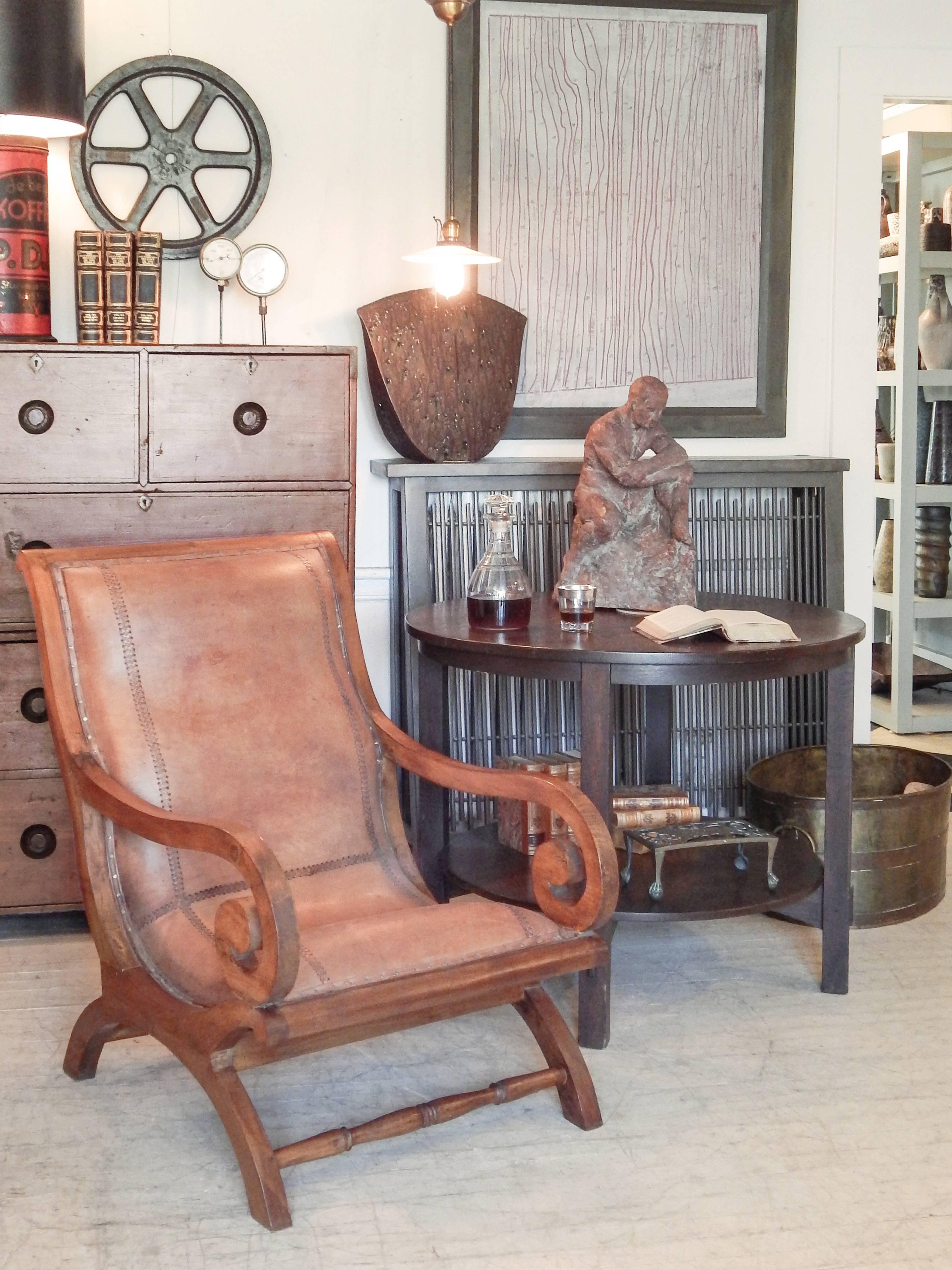 Leather and teak plantation chair with scrolled arms, original braided stitched leather with nail-head trim.