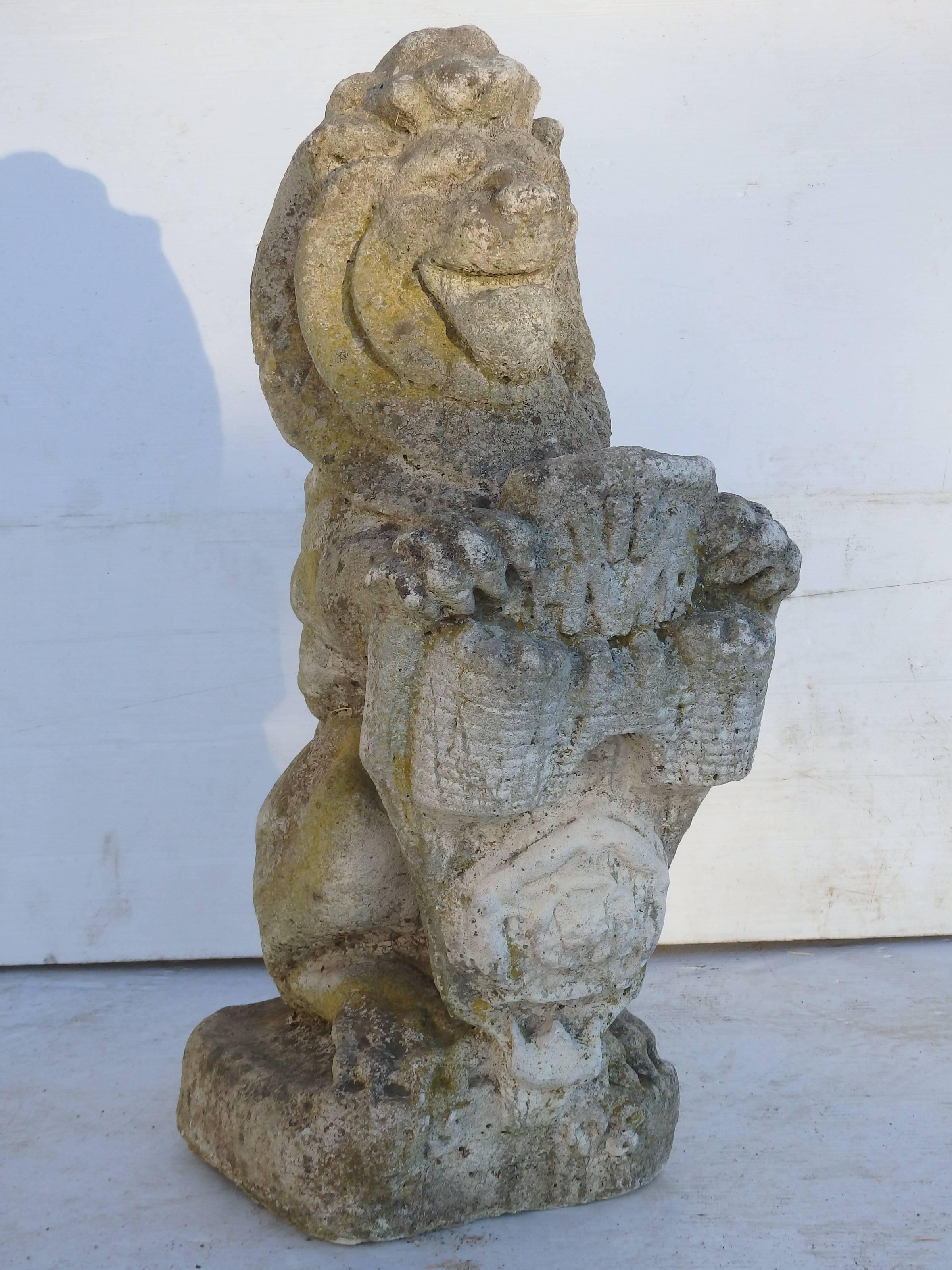 Pair of English composition stone lions, with shields with great patina.