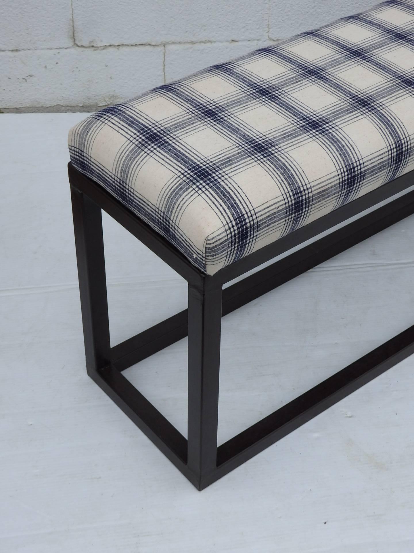 Long narrow bench with iron base and upholstered seat with in French vintage check fabric.