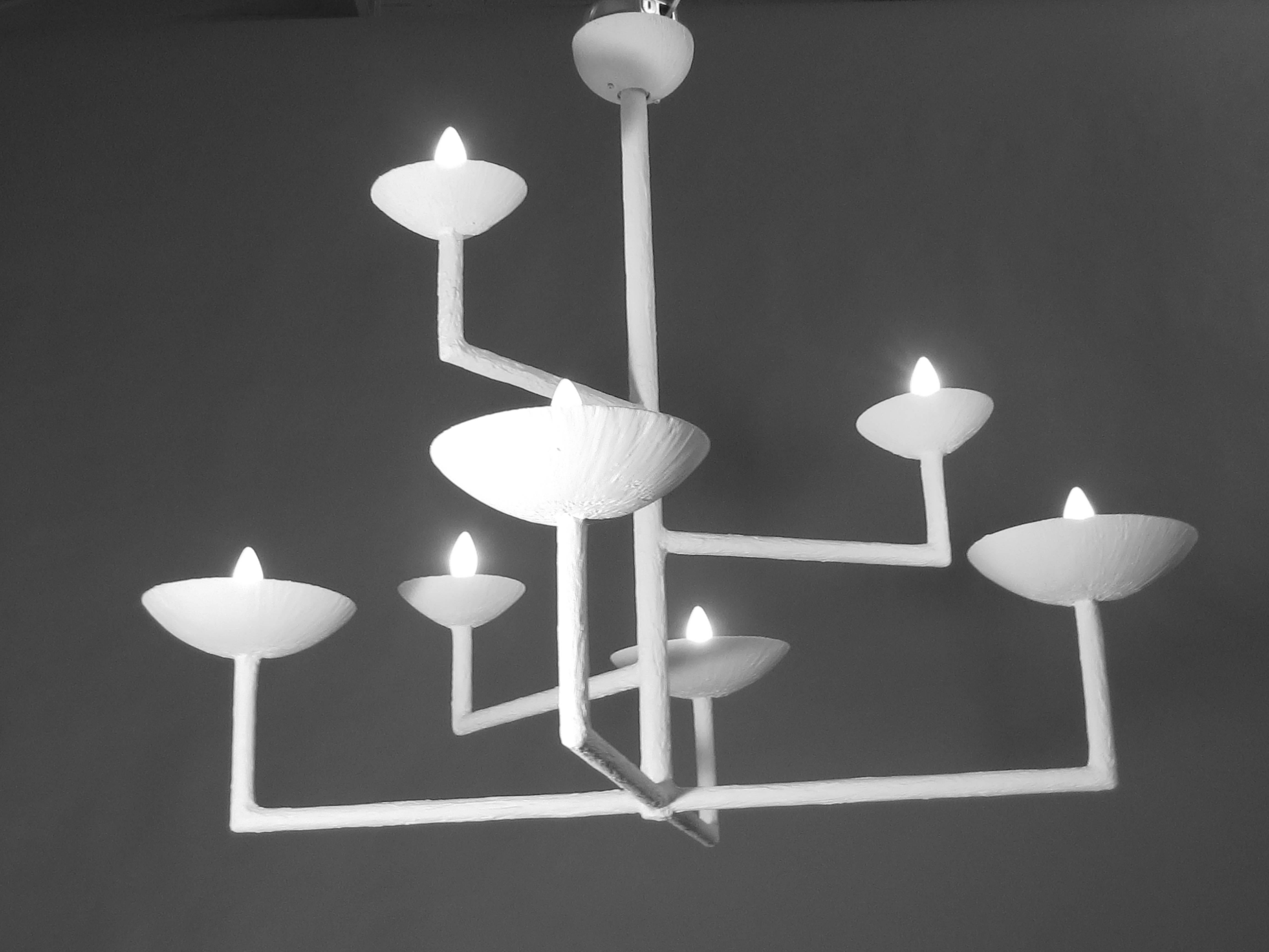 Metal based, plaster covered chandelier.  Textured plaster, intruiging piece.  Seven bulbs four lower ones of equal height with top three at various ascending heights.  Modern appealing piece.