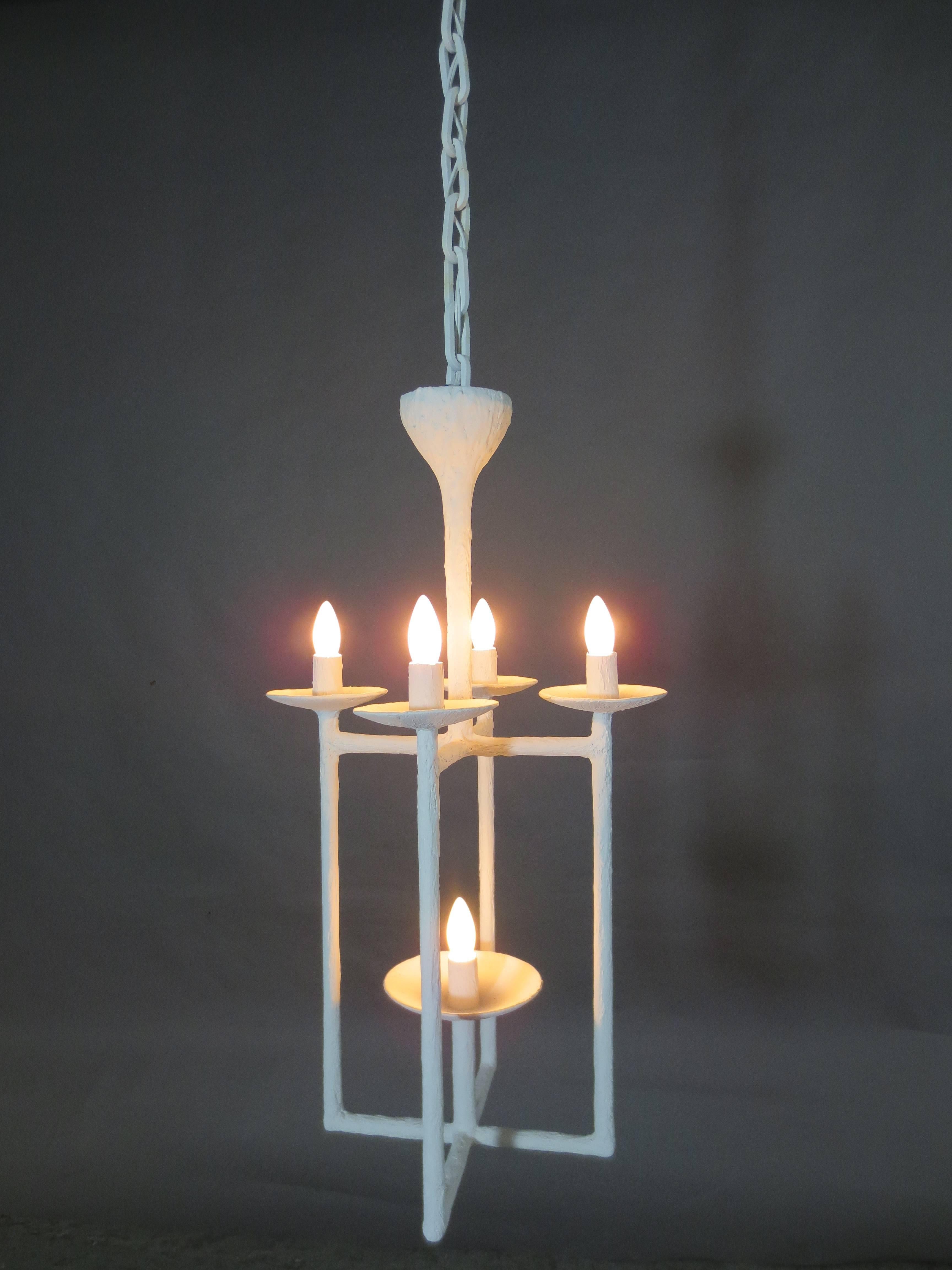 Lantern Chandelier in White Plaster.  Five bulbs, four above arms, one reaching from center on the bottom base. Can be made with custom chain lengths as pictured. All chandeliers are custom and made to order. Available in a variety of finishes. 