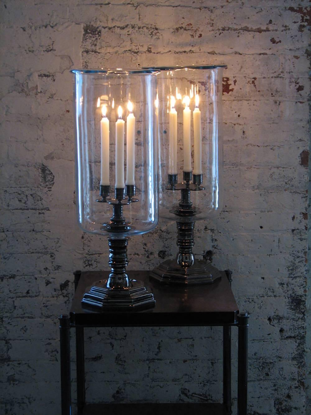 A large, Louis XIV style hurricane with black nickel-plated metal-work and a handblown shade with a rolled lip at the top, designed for use with three candles.