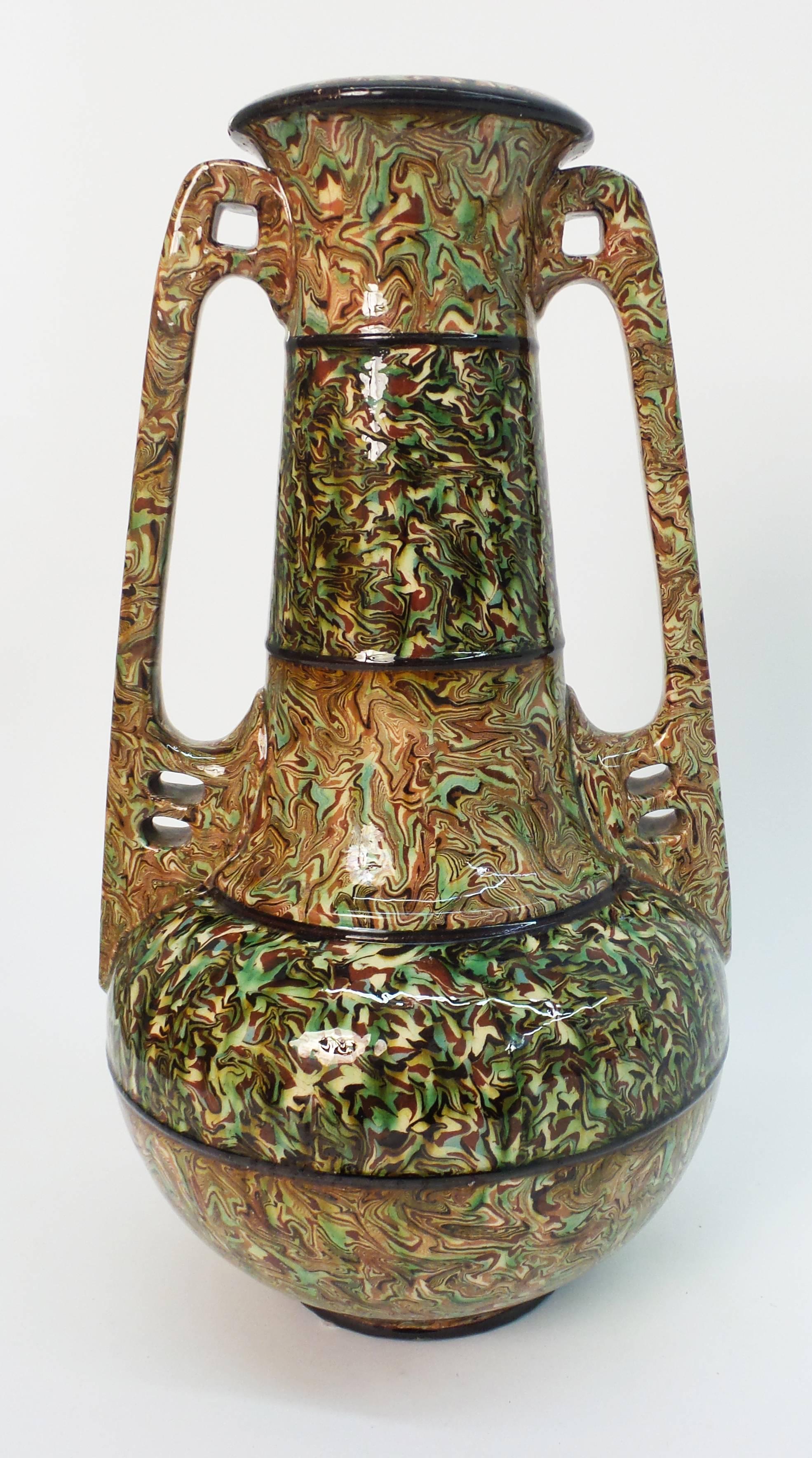 A rare, large mixed earth pottery vase of Art Nouveau design having pierced handles and made by Aurore Pichon. Signed, "Pichon a Uzes". 

A photo in Pichon book shows Aurore Pichon with an example of this model at his back.