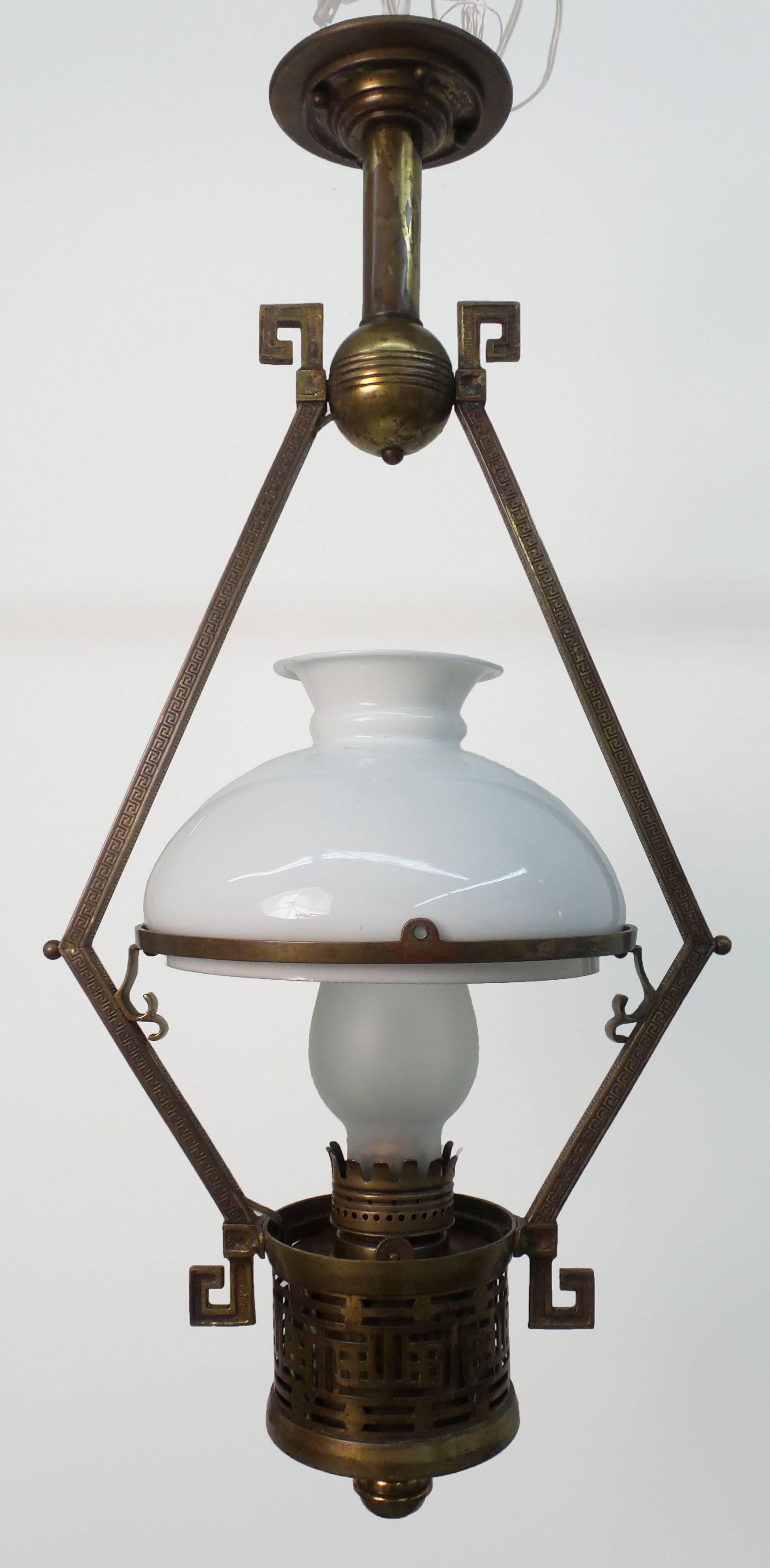An English aesthetic period oil lamp executed in brass with Greek key and fretwork designs, circa 1885. Converted to electricity.