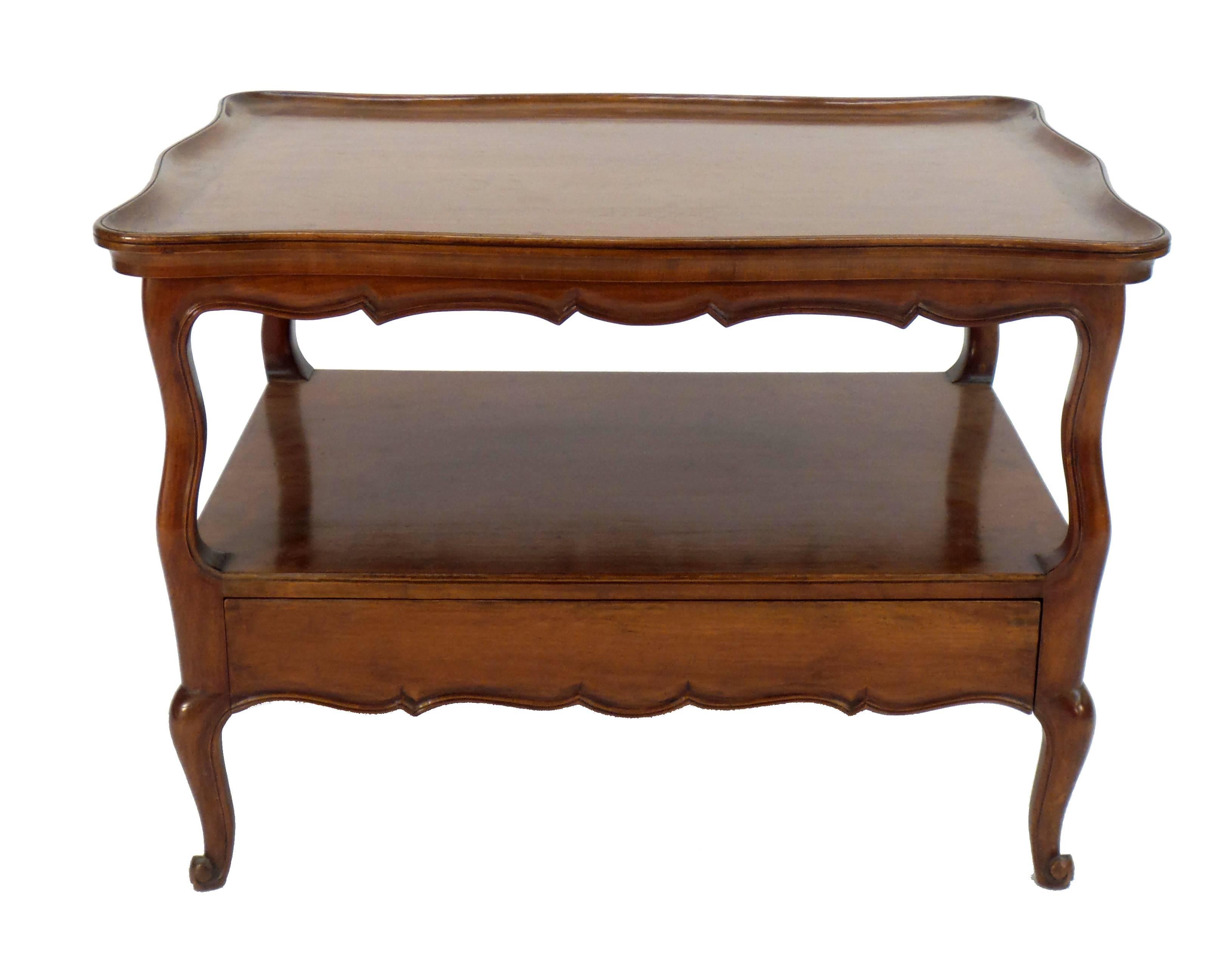 A 1960s vintage Louis XV style low coffee table, a model originally designed for Syrie Maugham in the late 1940s, having a fixed tray top with two extending tirettes and a blind drawer in the lower portion.