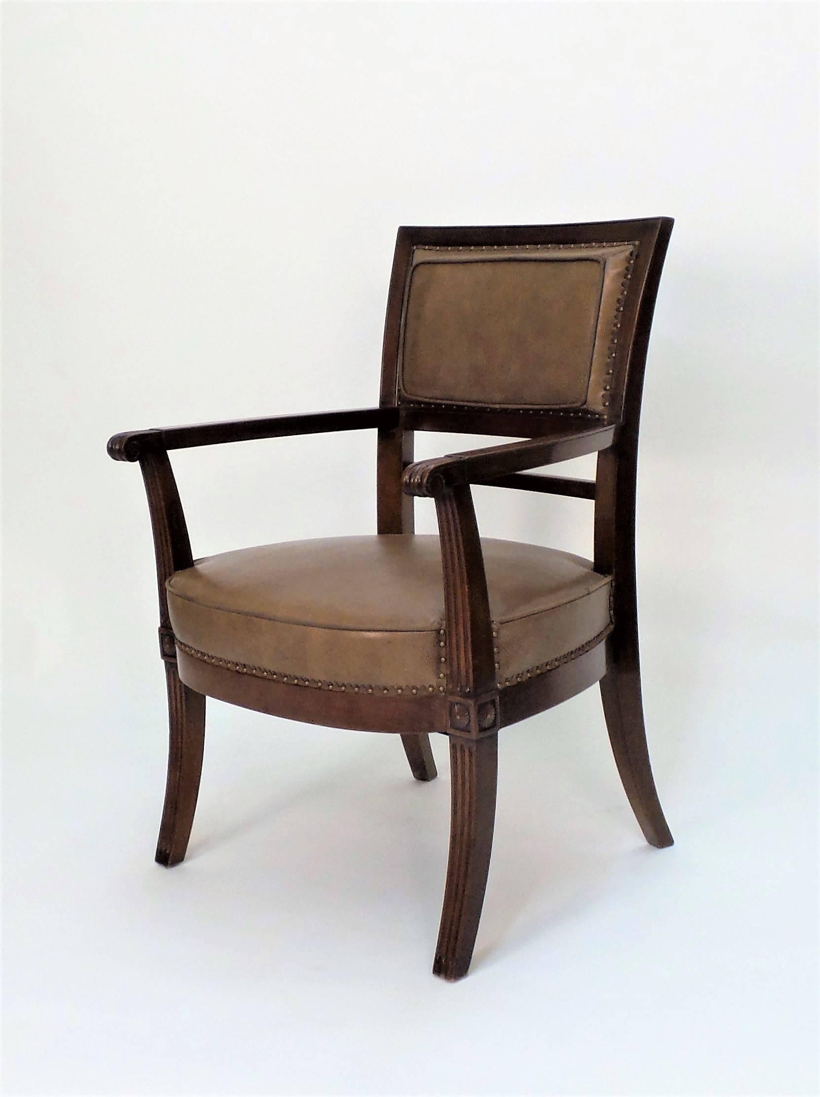An Empire style armchair inspired by a design by master chairmaker J.B.B. Demay, shown with "en tableau" boxed leather upholstery, hand-tied sprung seat, with spaced nails over a cut-leather tape trim. Custom upholstery and finishes