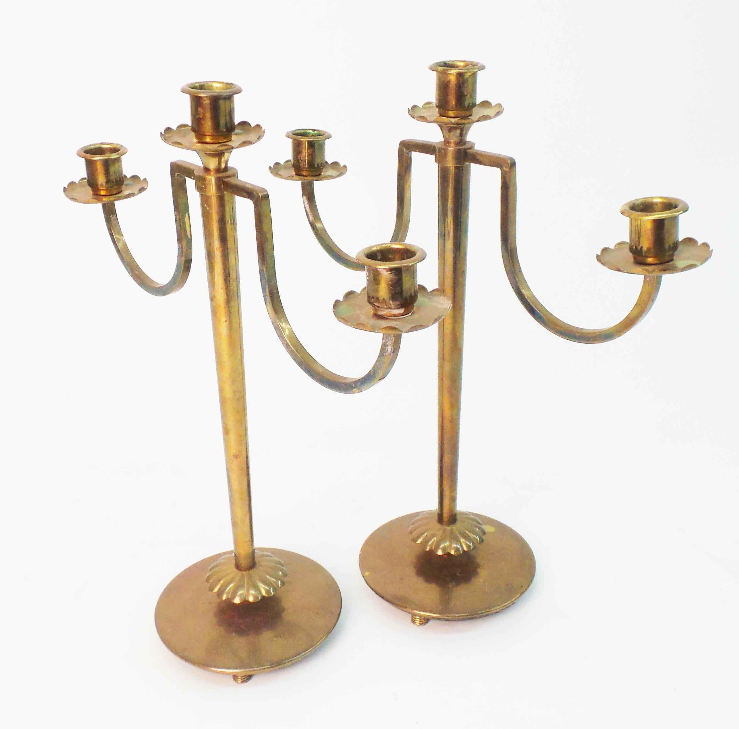 A pair of American, Art Deco period three-light candelabra designed by Walter Von Nessen and executed in brass. Signed and hall-marked 'Chase', circa 1930. The Chase Brass and Copper Co. was founded in Waterbury, Ct., in 1876.