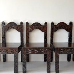 Set of six hand-carved dark-stained wood dining chairs with chevron motifs