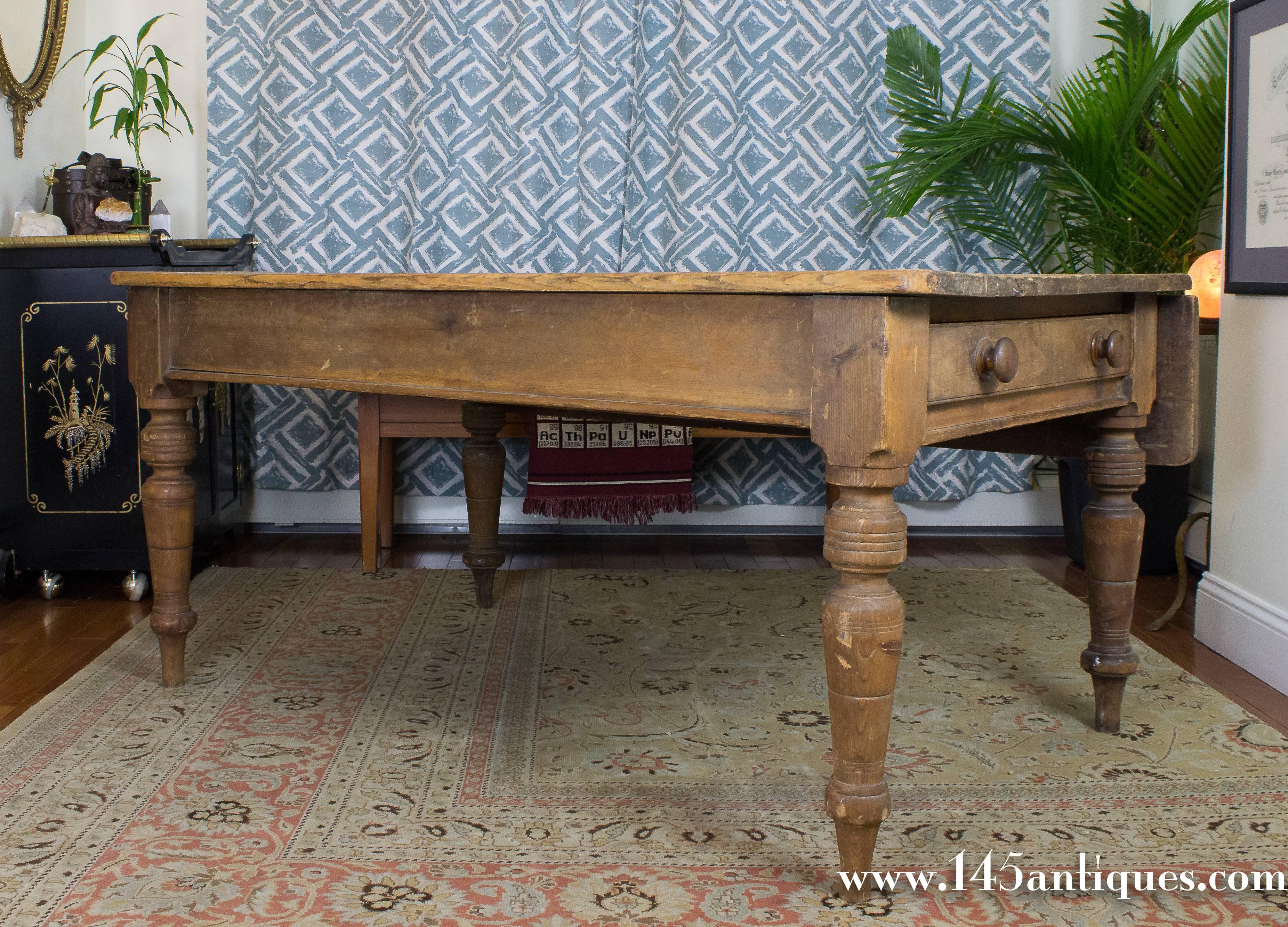 19th century English farm table made of solid pine wood with drop-leaf on one side (adds 11