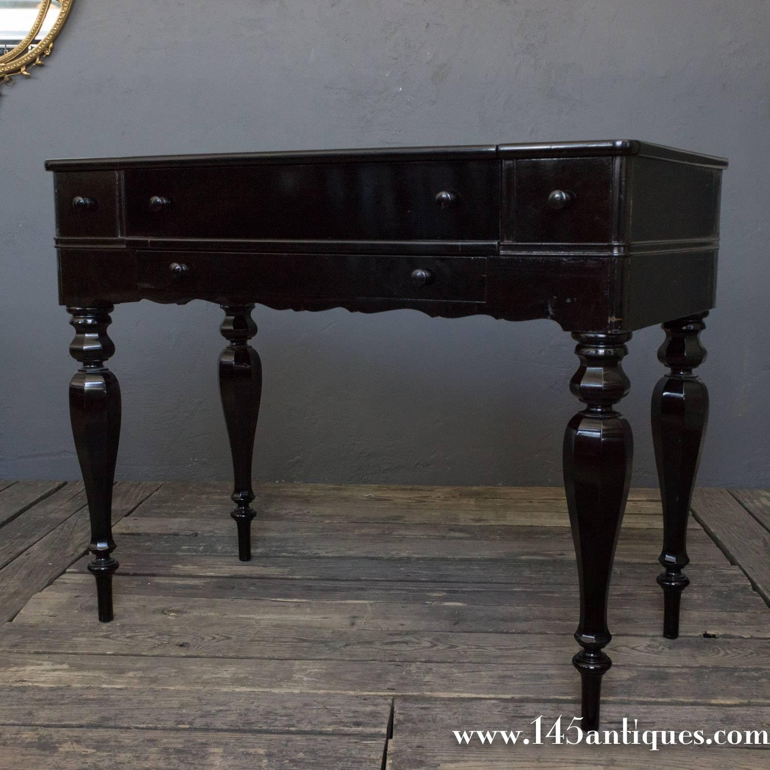 American 1920s new-classical ebonized drop top desk. It has three drawers and a handled drop front for the desk. The inside has pigeon holes for letters and stationary and a drawer.
