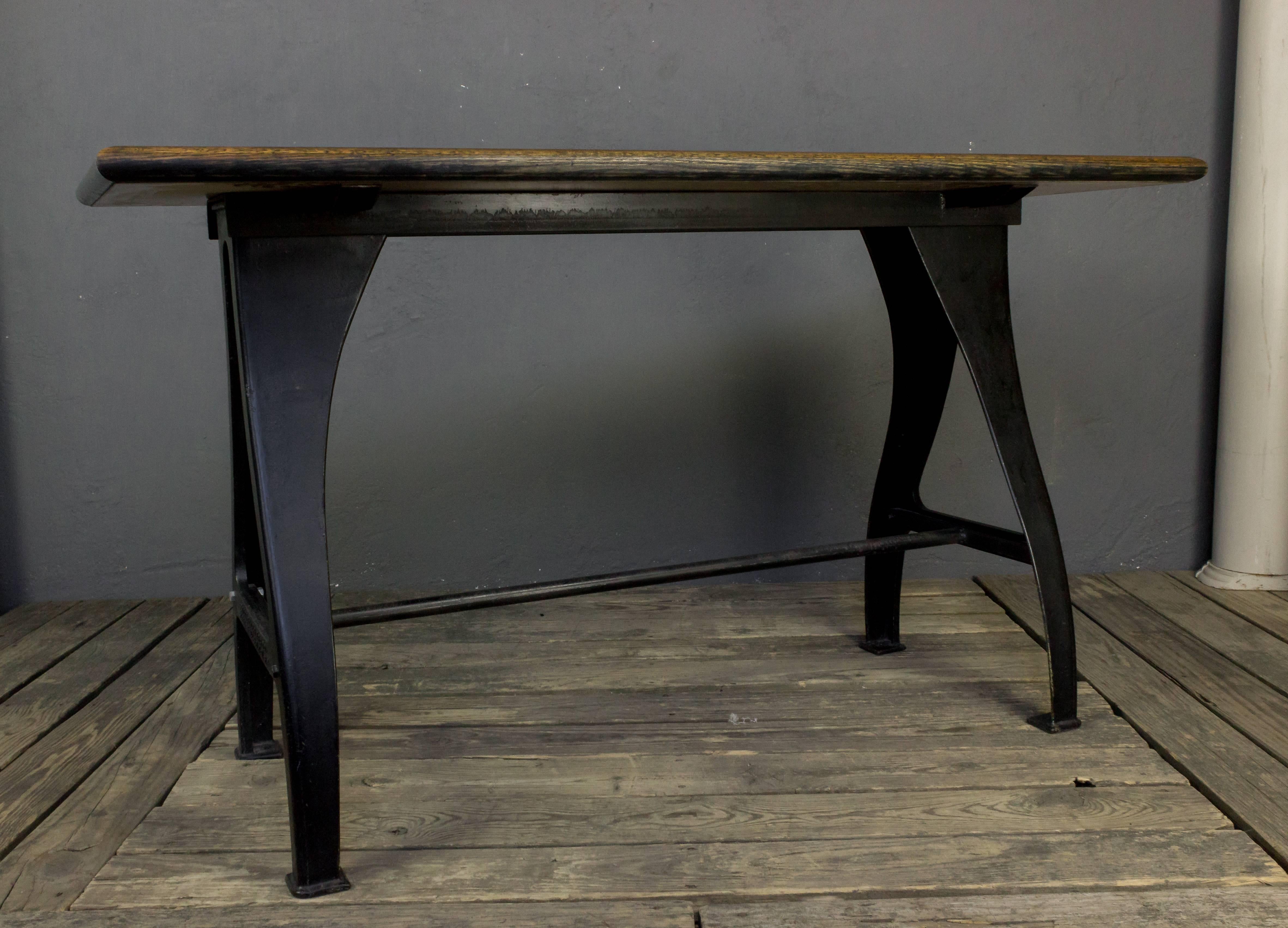 Heavy iron base Industrial table with attached wood surface and black paint finish. Marked Seneca Falls MFG Co.