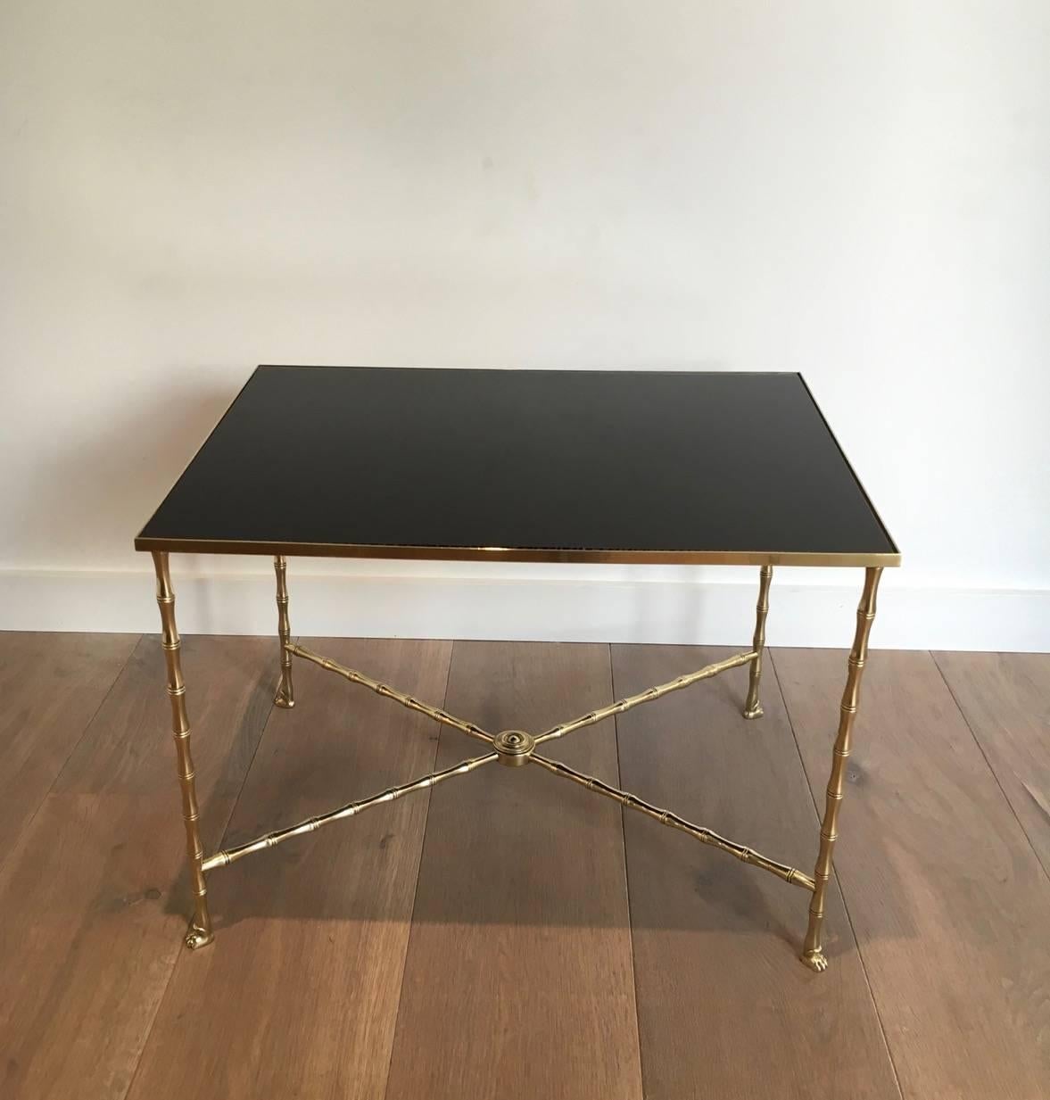 Maison Bagués gilt bronze coffee table, faux-bamboo frame with claw feet. The top is black glass. This item is currently in France, please allow 2 to 4 weeks delivery to New York. Shipping costs from France to our warehouse in New York included in