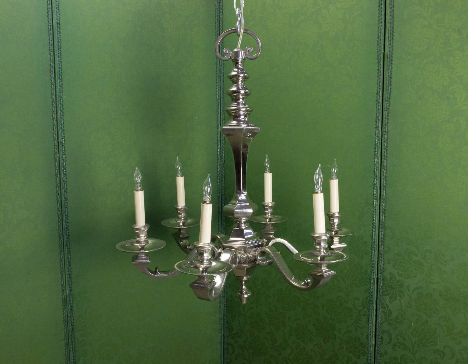 A stunning French 1940s nickel-plated bronze chandelier with six arms. This French chandelier is a masterpiece of vintage lighting design. With its six arms and intricate details, it exudes an air of elegance and sophistication. The nickel-plated